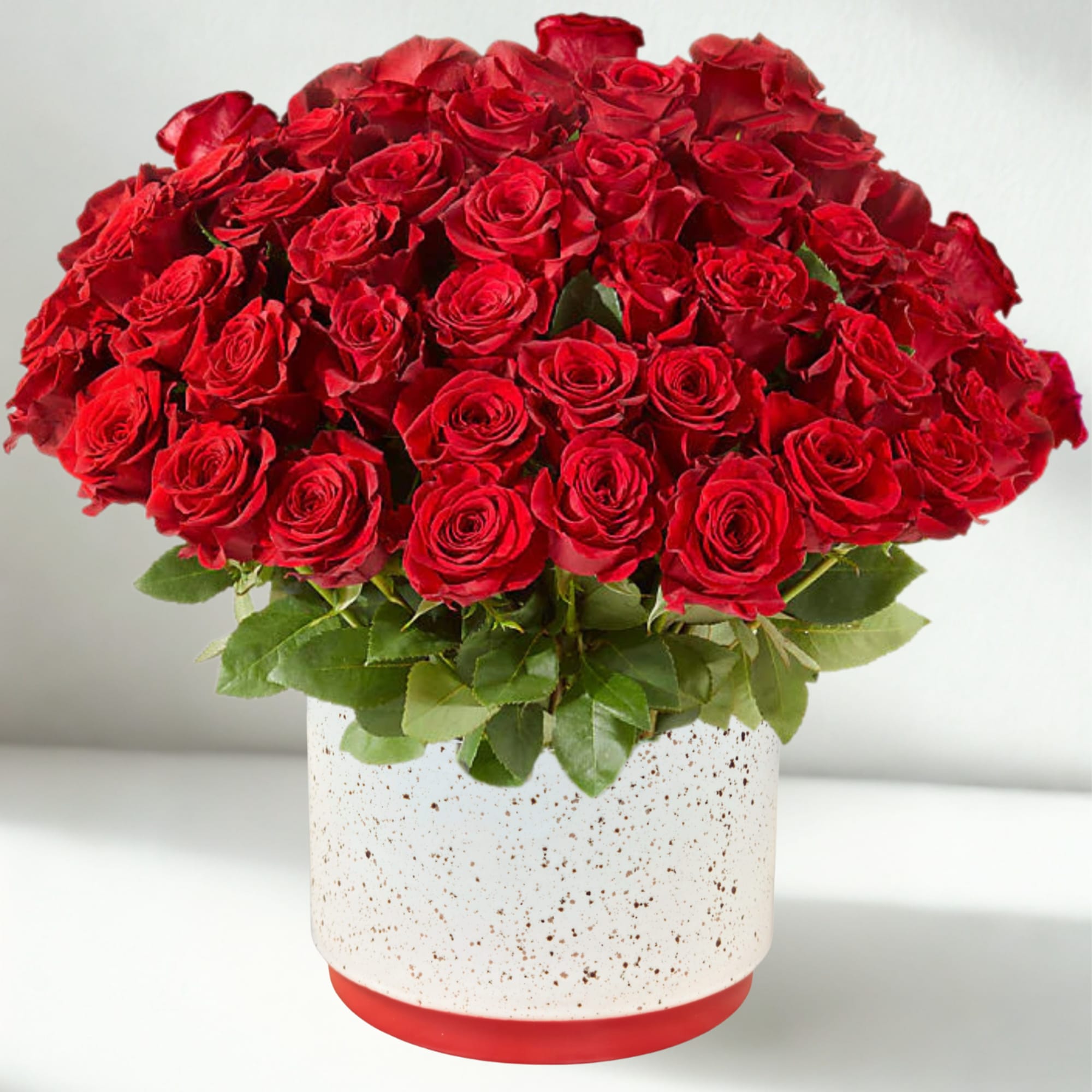 Bouquet of red roses in a white speckled vase