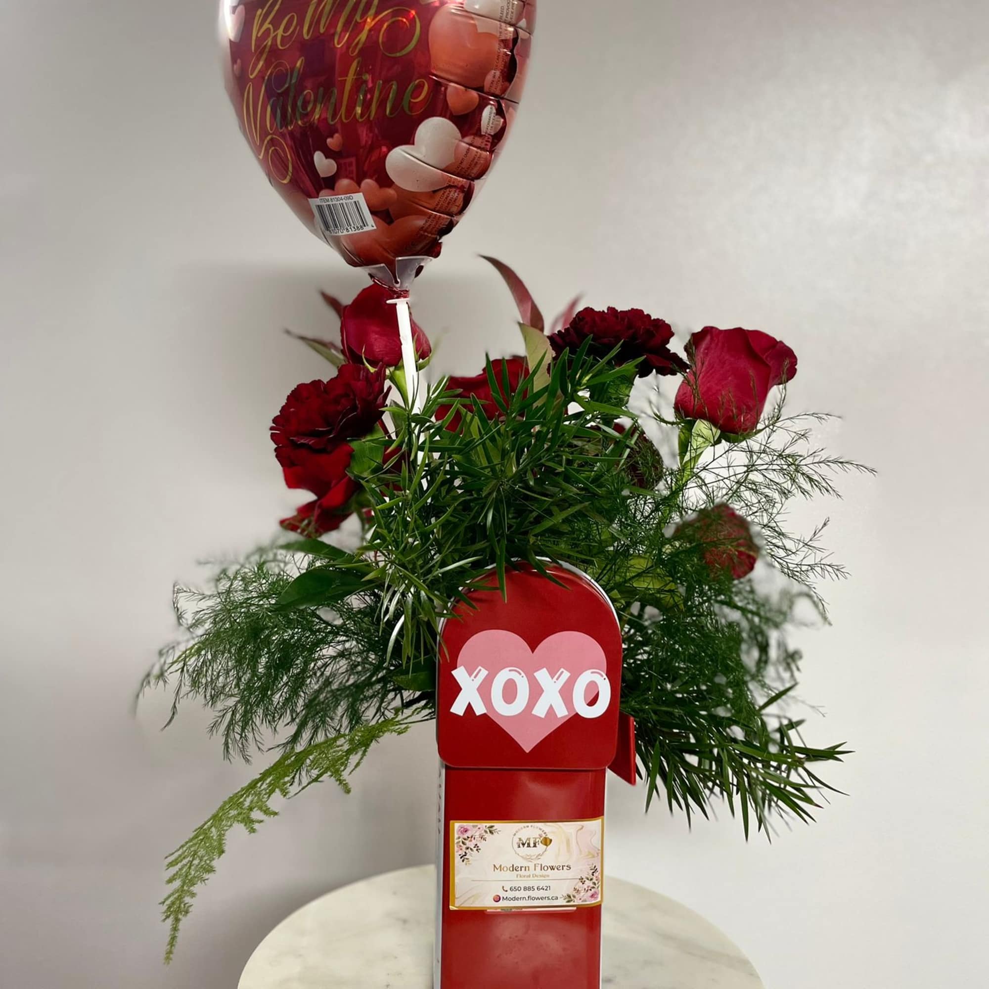 Red rose arrangement with a heart-shaped Valentine balloon and XOXO gift box