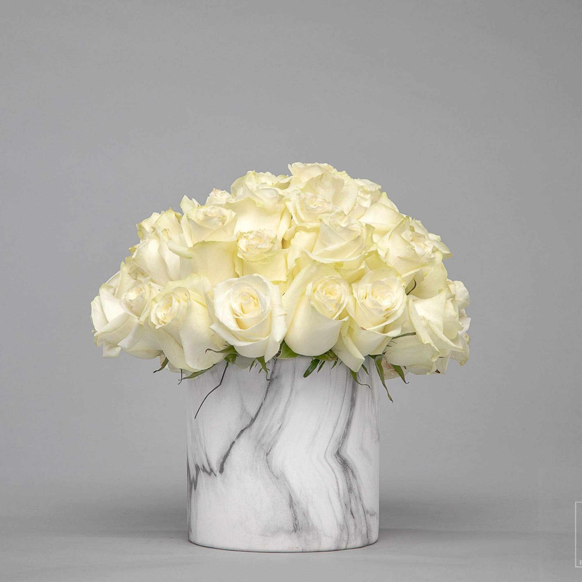 White rose bouquet in a marble-patterned vase