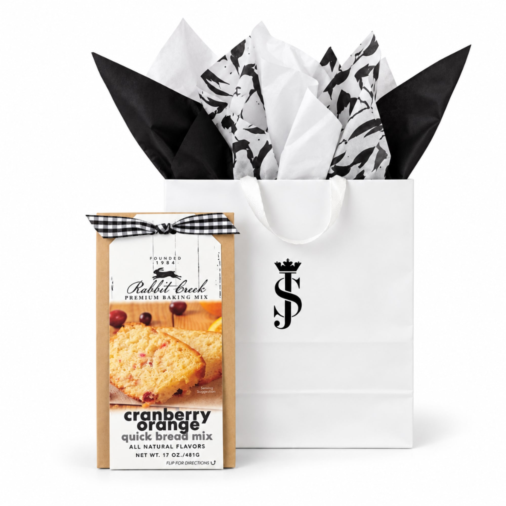Gift bag with tissue paper and a boxed cranberry orange bread mix