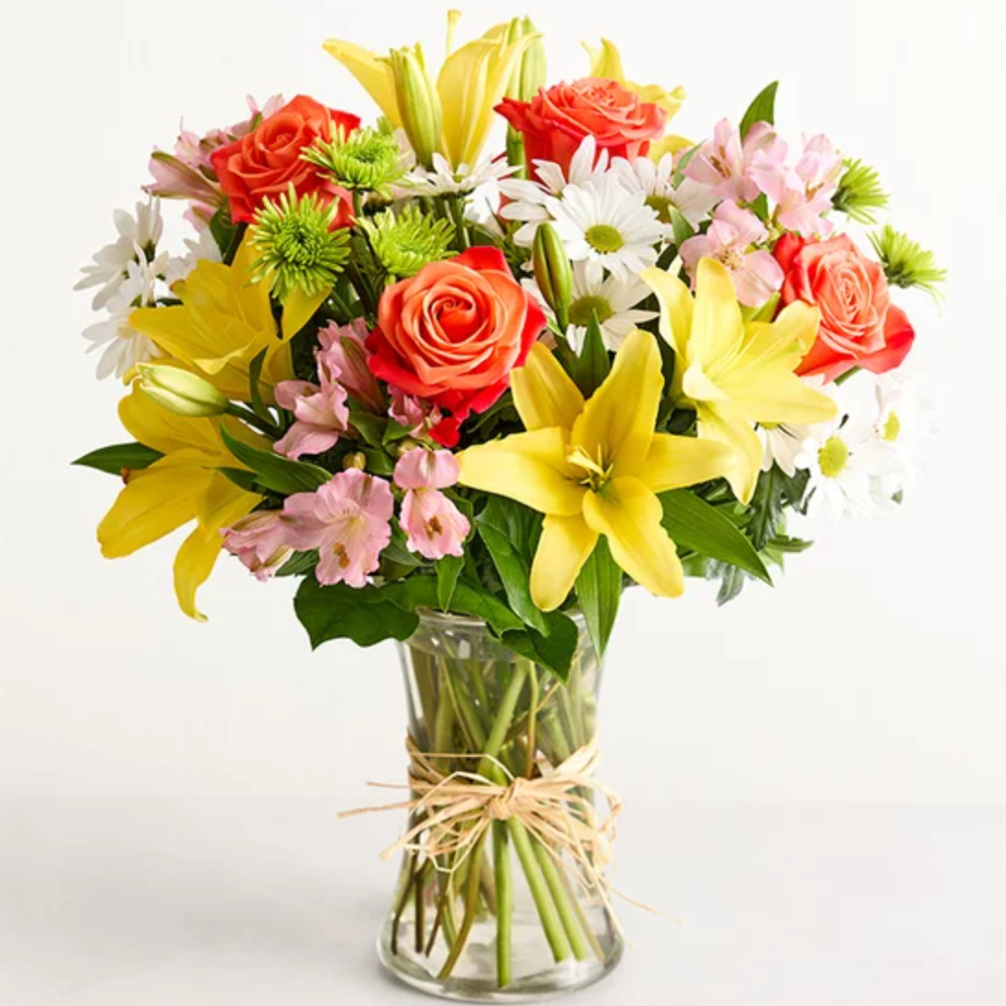 Mixed bouquet of roses, lilies, and daisies in a glass vase