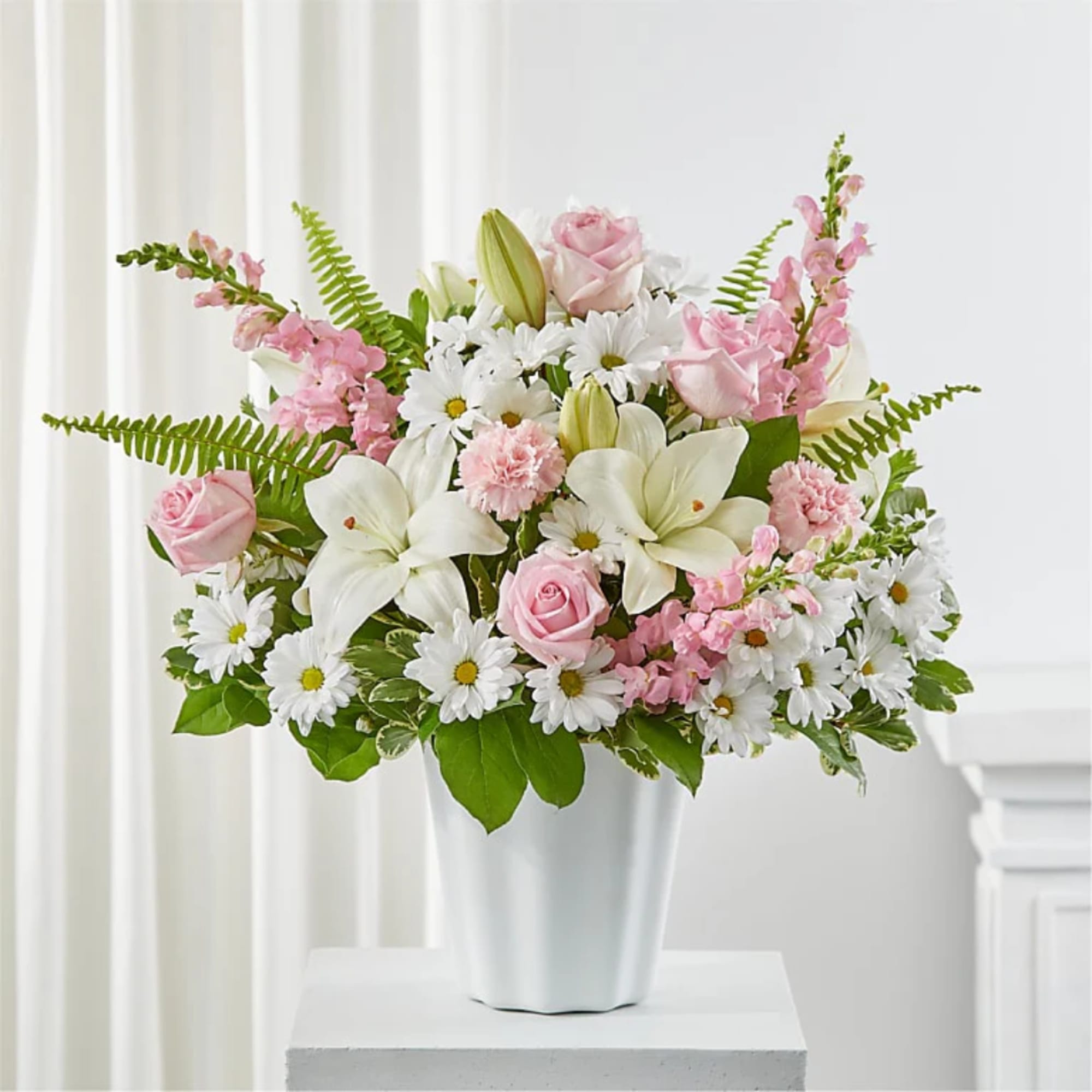 Pink roses and white lilies in a white vase