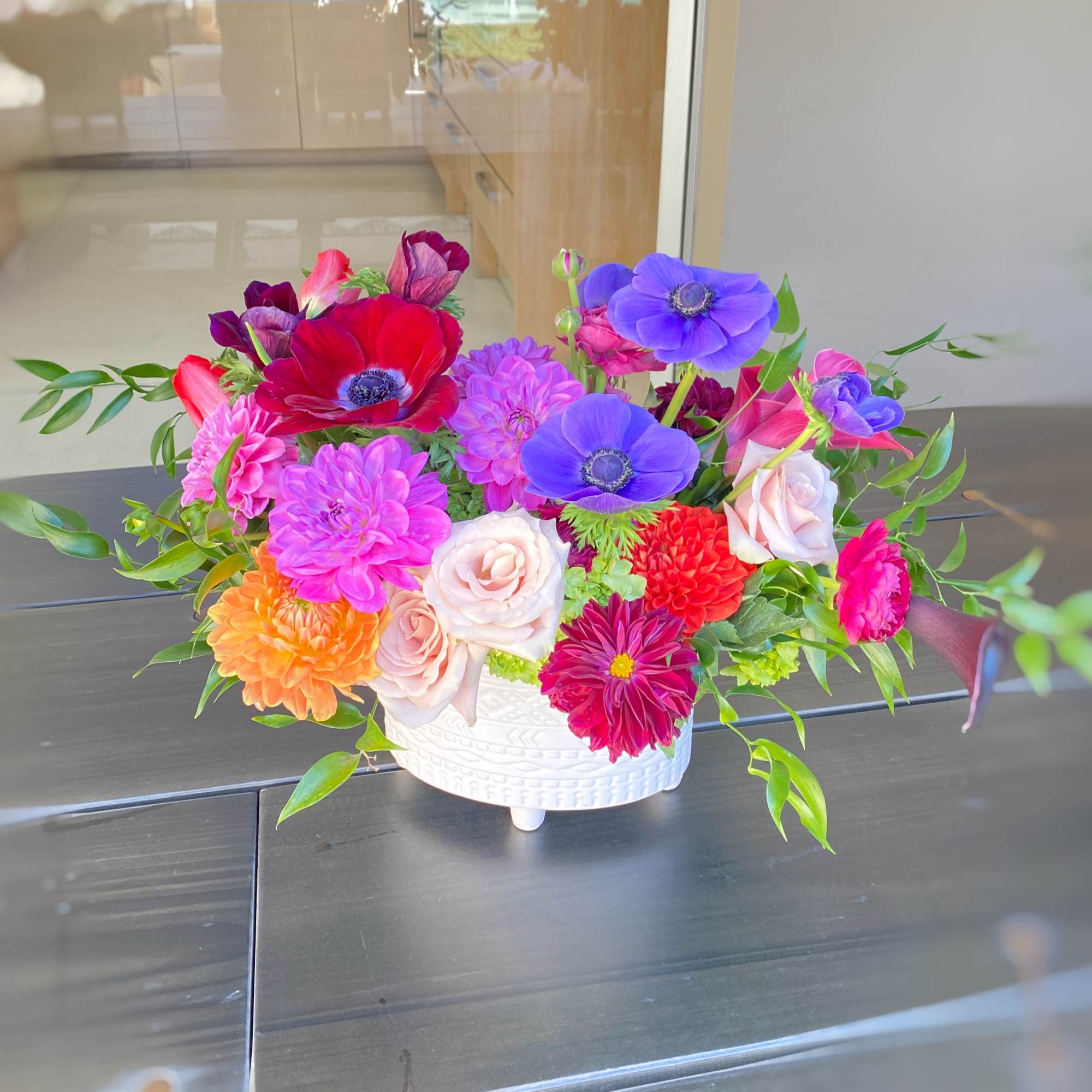Colorful mixed flower arrangement in a white ceramic bowl
