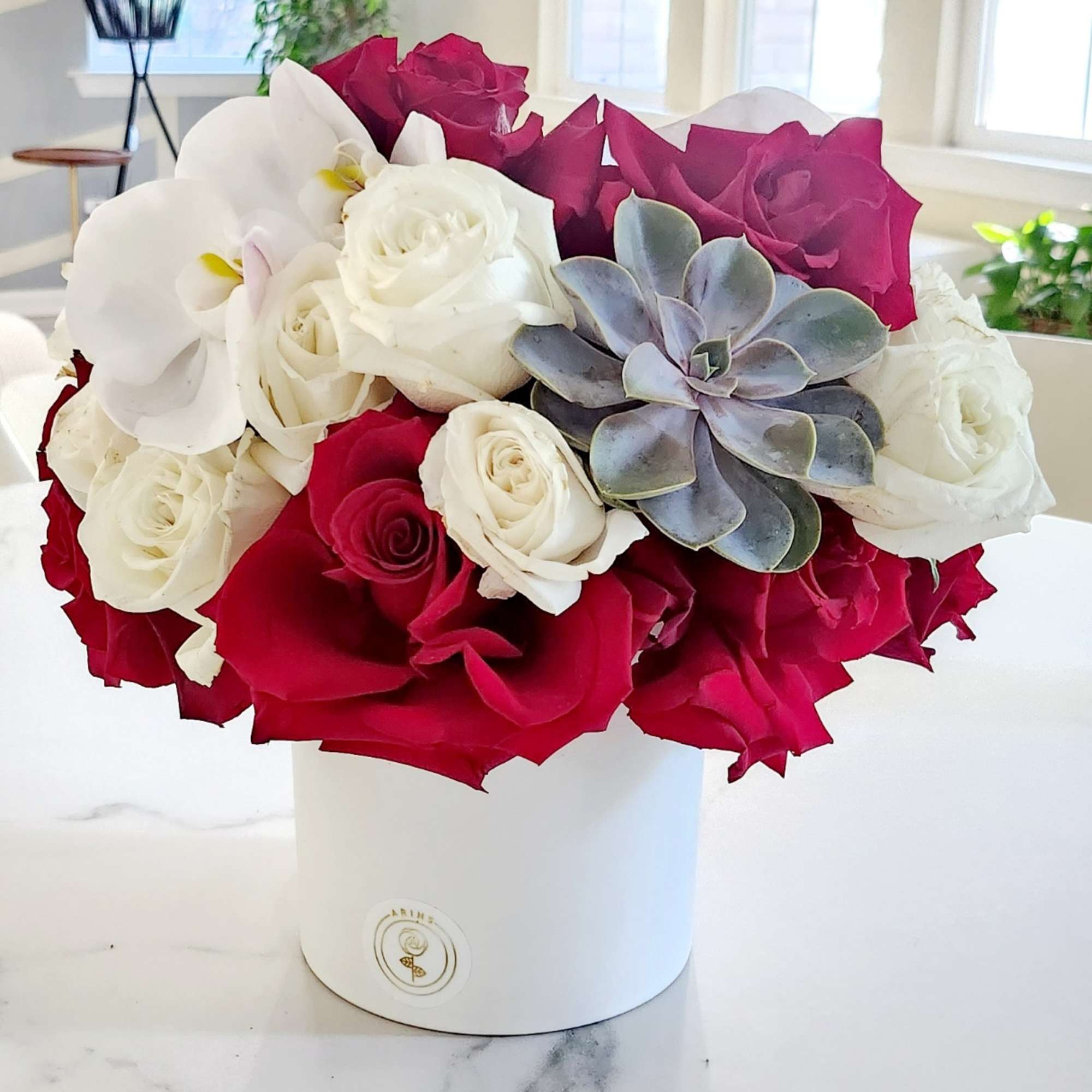 Bouquet of red and white roses with a succulent in a white hatbox