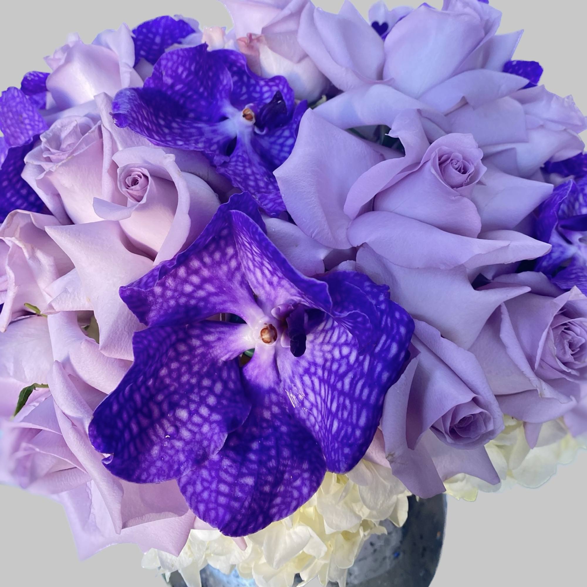 Lavender roses and purple orchids in a vase