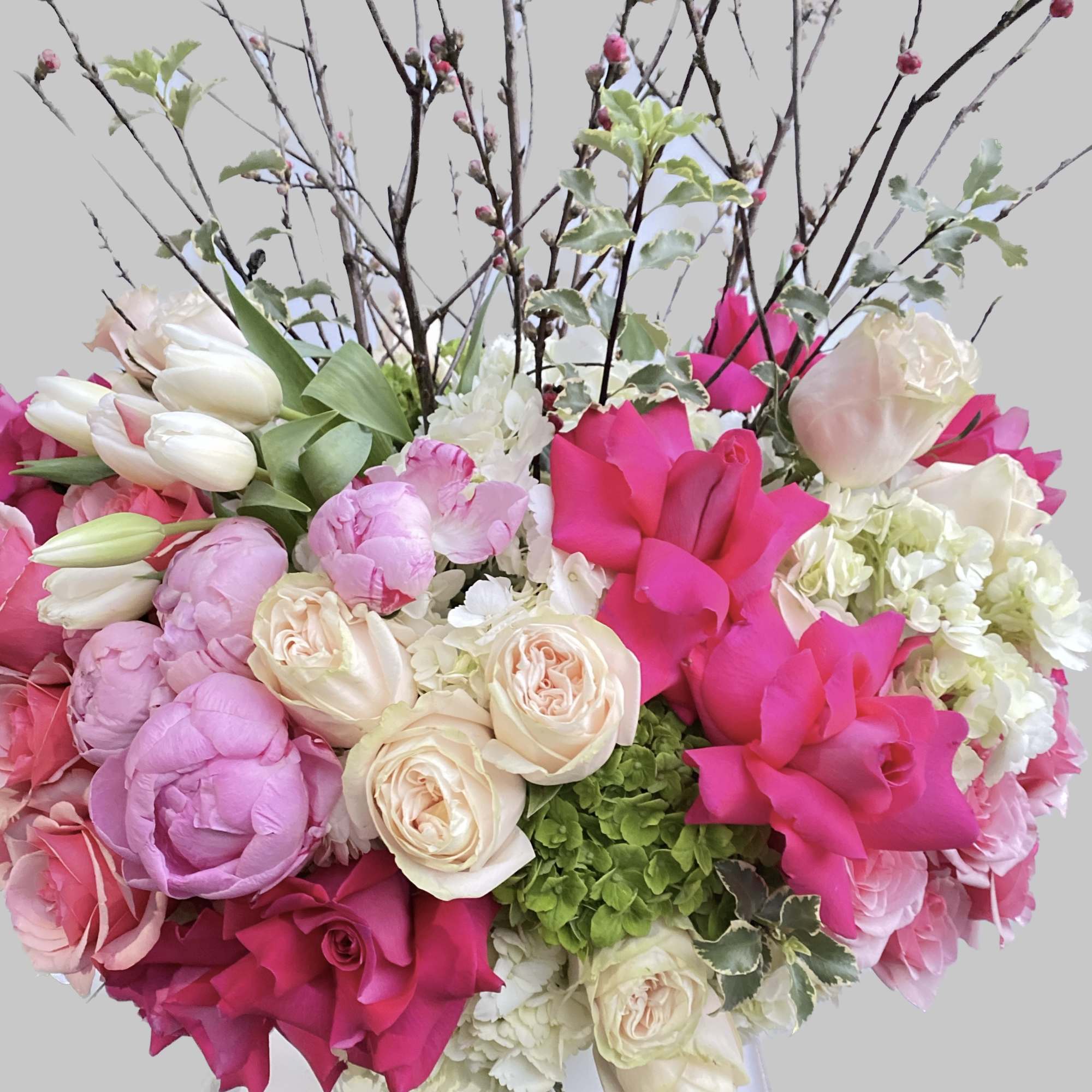 Pink and white floral arrangement in a white vase with tall branches, photo 2 of 2
