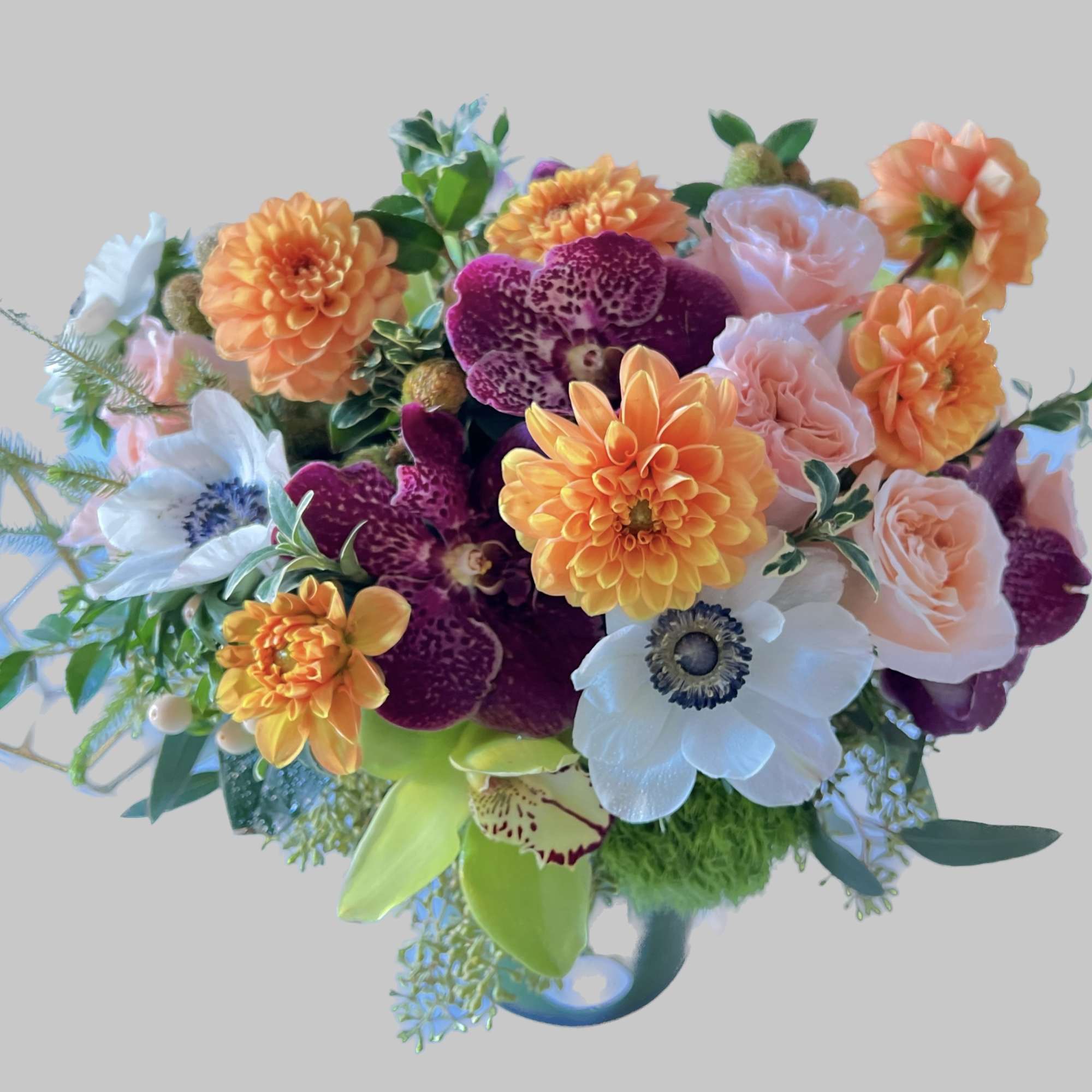 Colorful bouquet with orange dahlias, pink roses, and white anemones