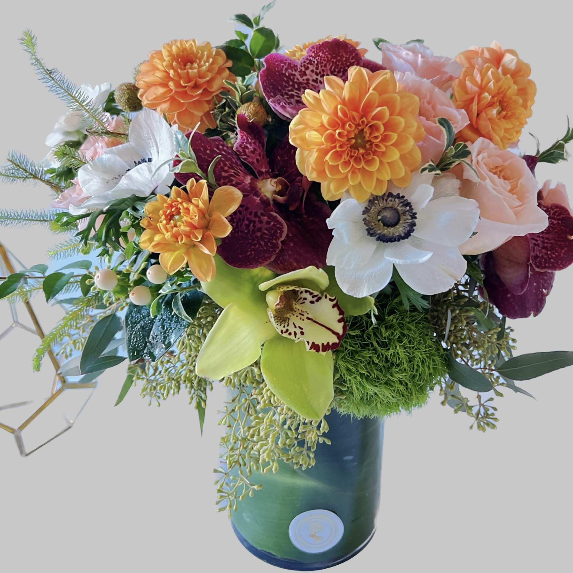 Colorful bouquet with orange, white, pink, and purple flowers in a blue vase