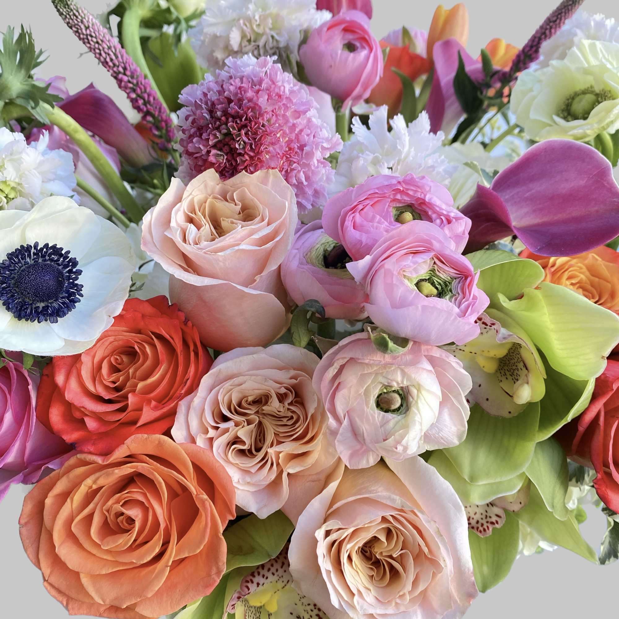 Mixed bouquet with roses, ranunculus, calla lilies, and orchids