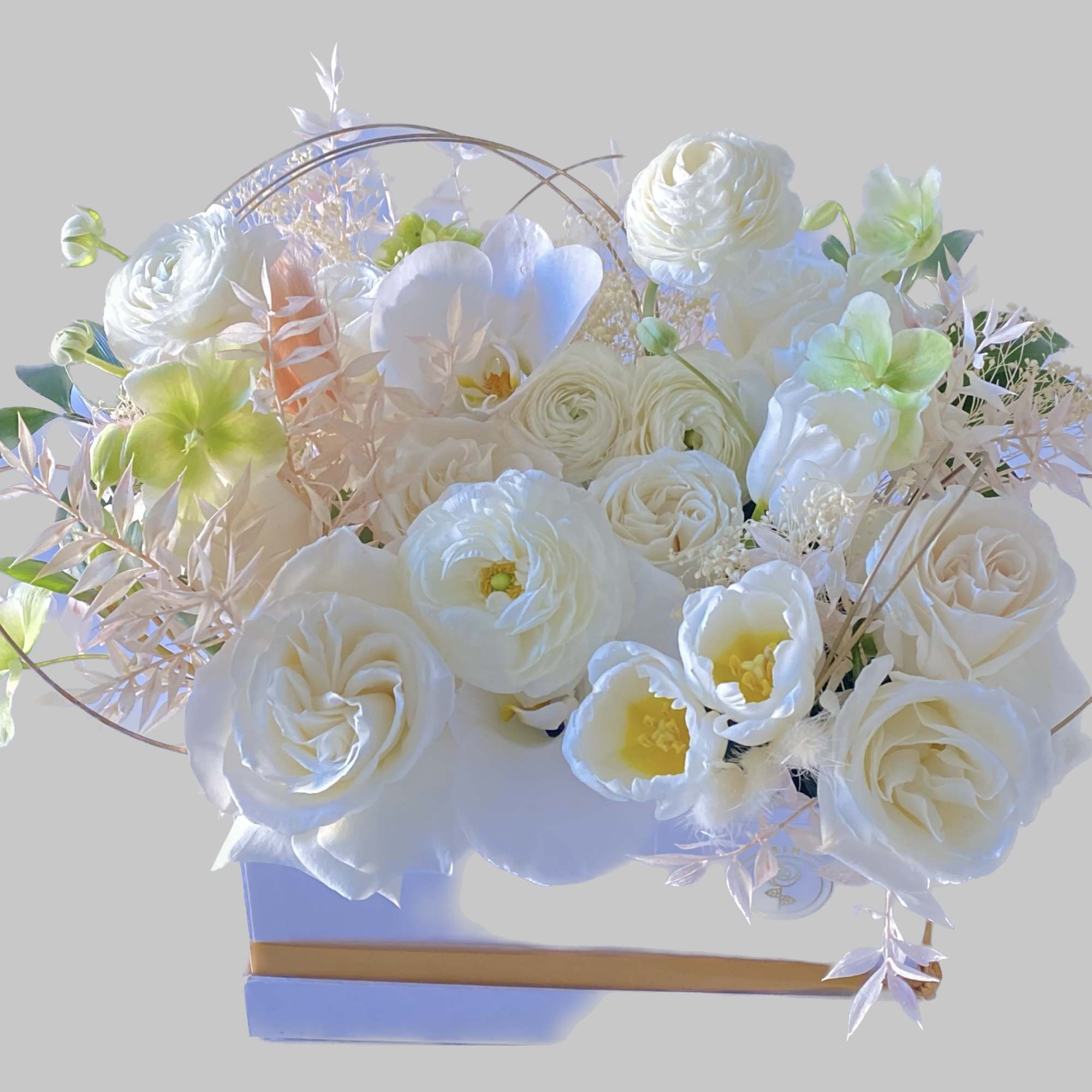 White floral arrangement in a rectangular box with pale green accents