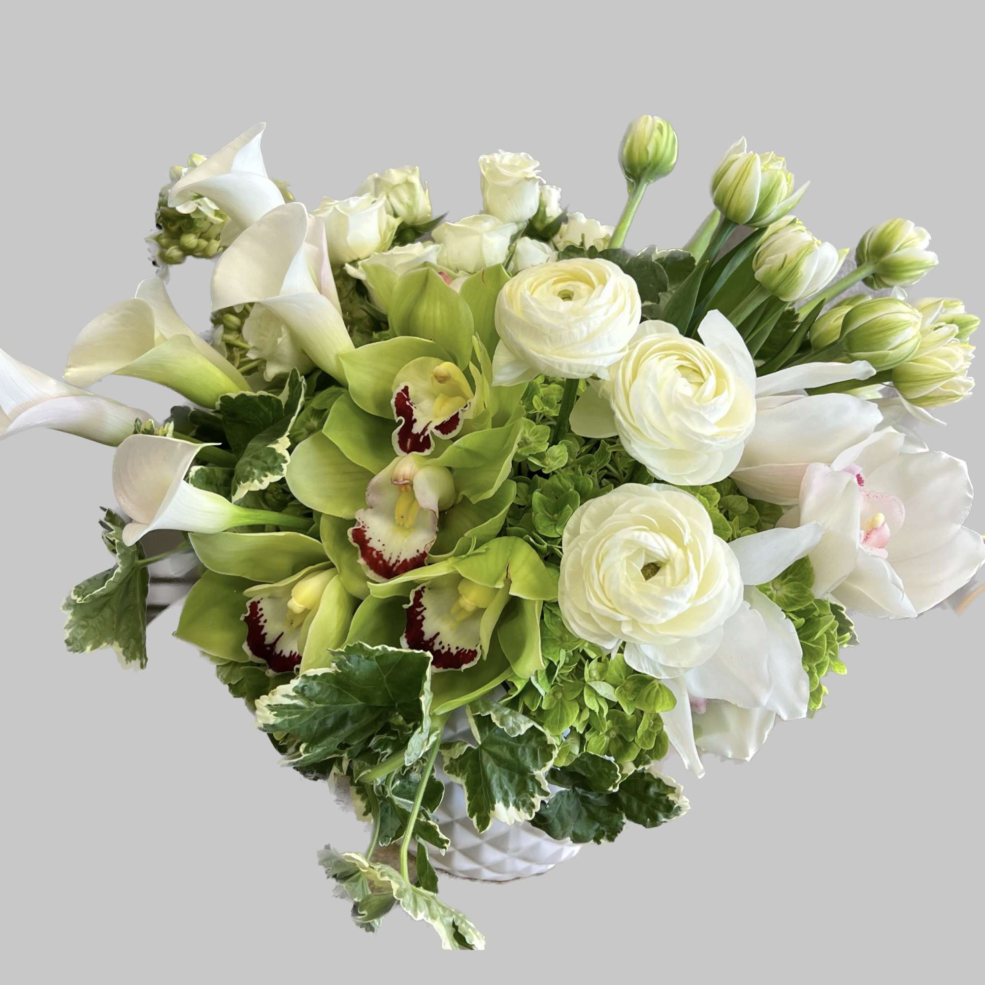White and green floral arrangement in a white vase