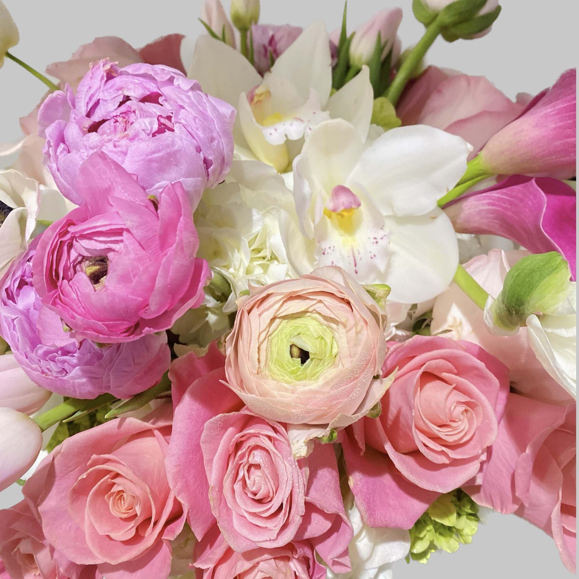 Pink roses and white orchids mixed with pale ranunculus