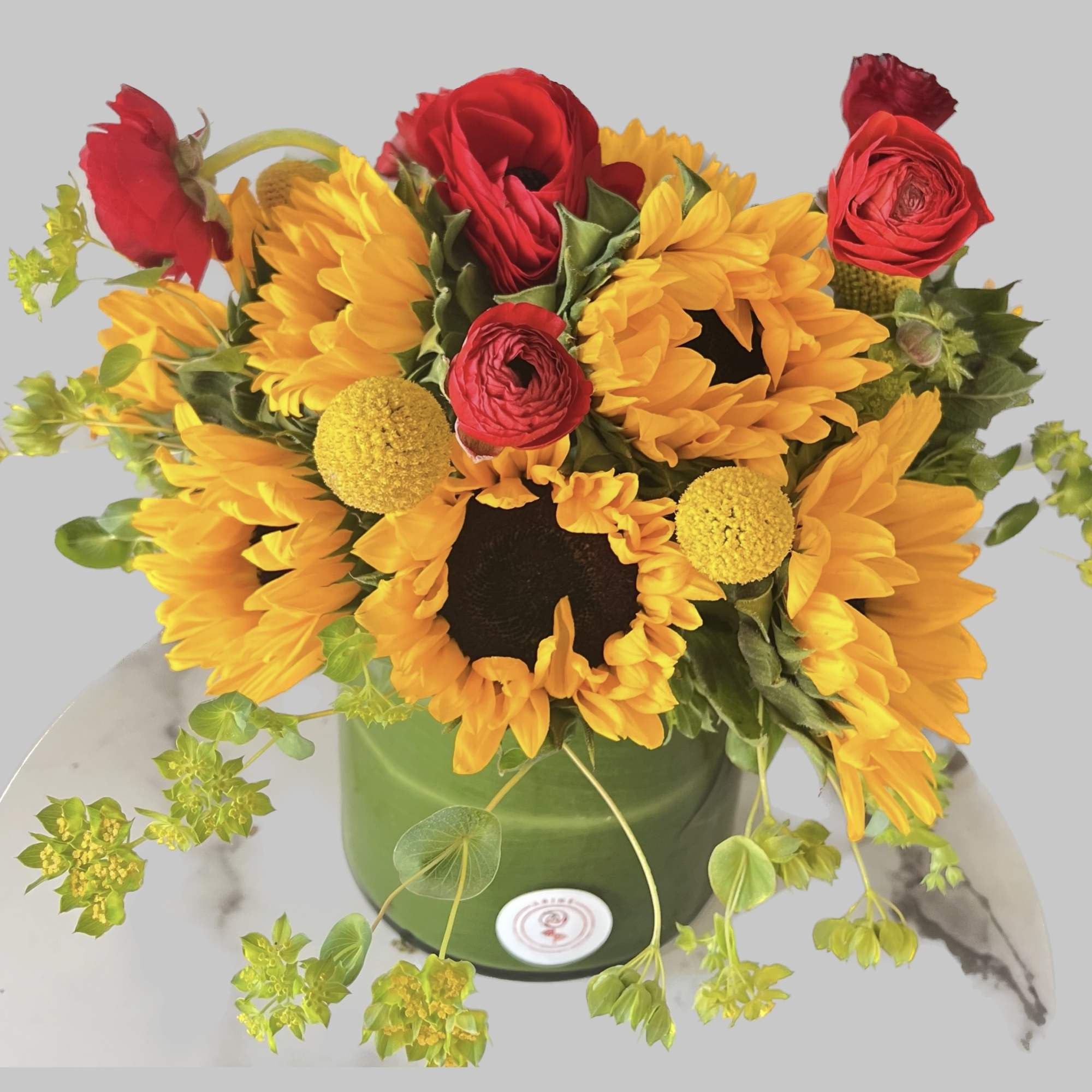 Sunflower and red rose arrangement in a green container