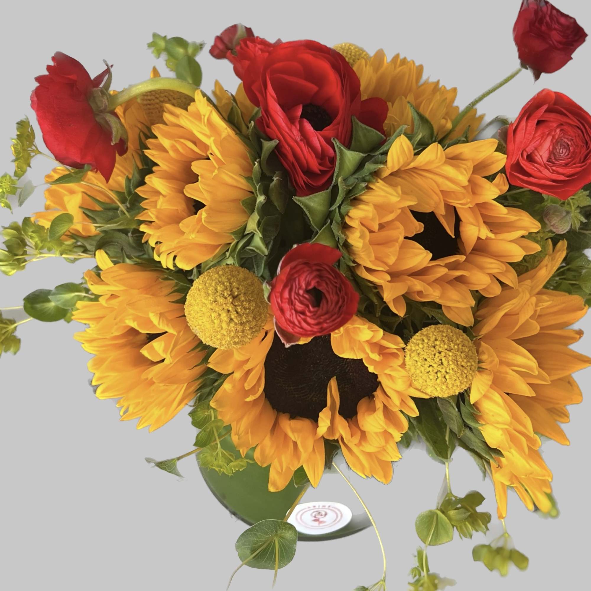 Bouquet of sunflowers and red roses in a glass vase