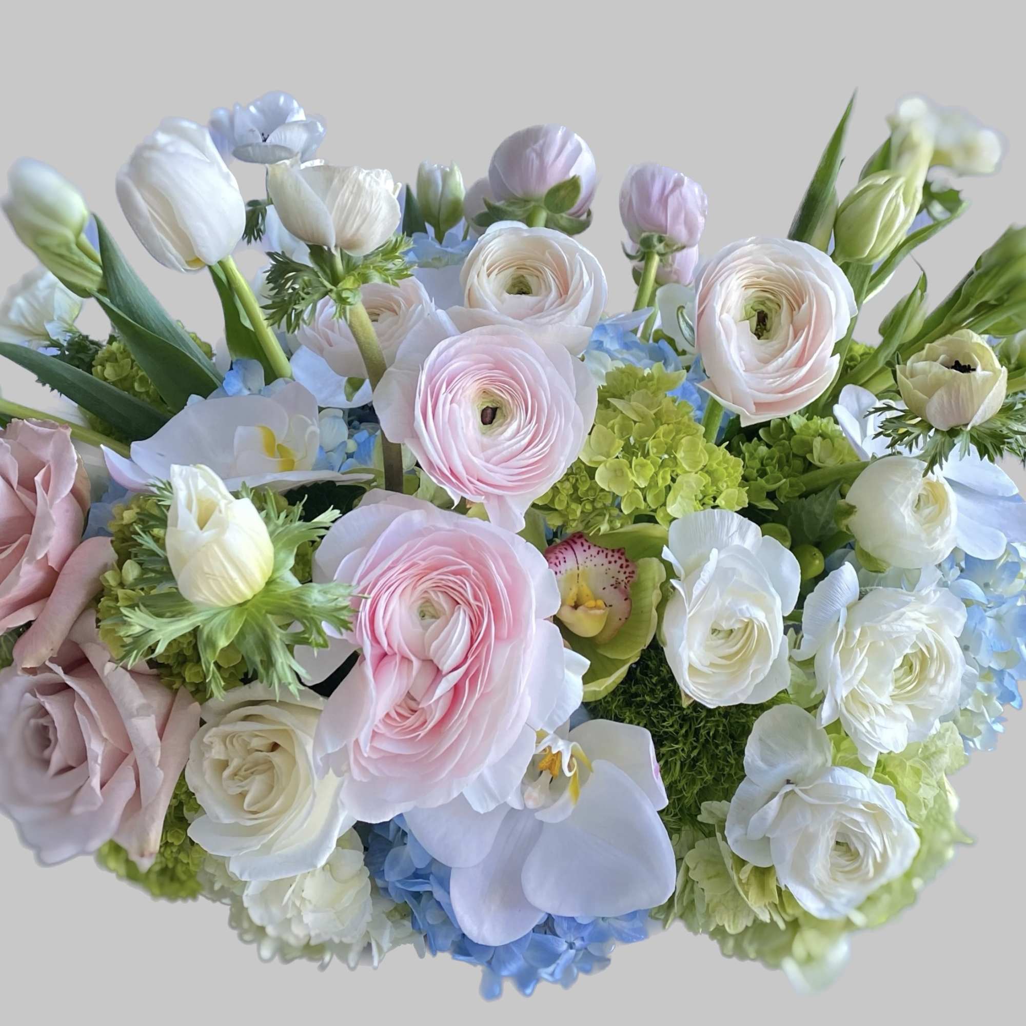 Pastel bouquet with roses, ranunculus, orchids, and hydrangeas