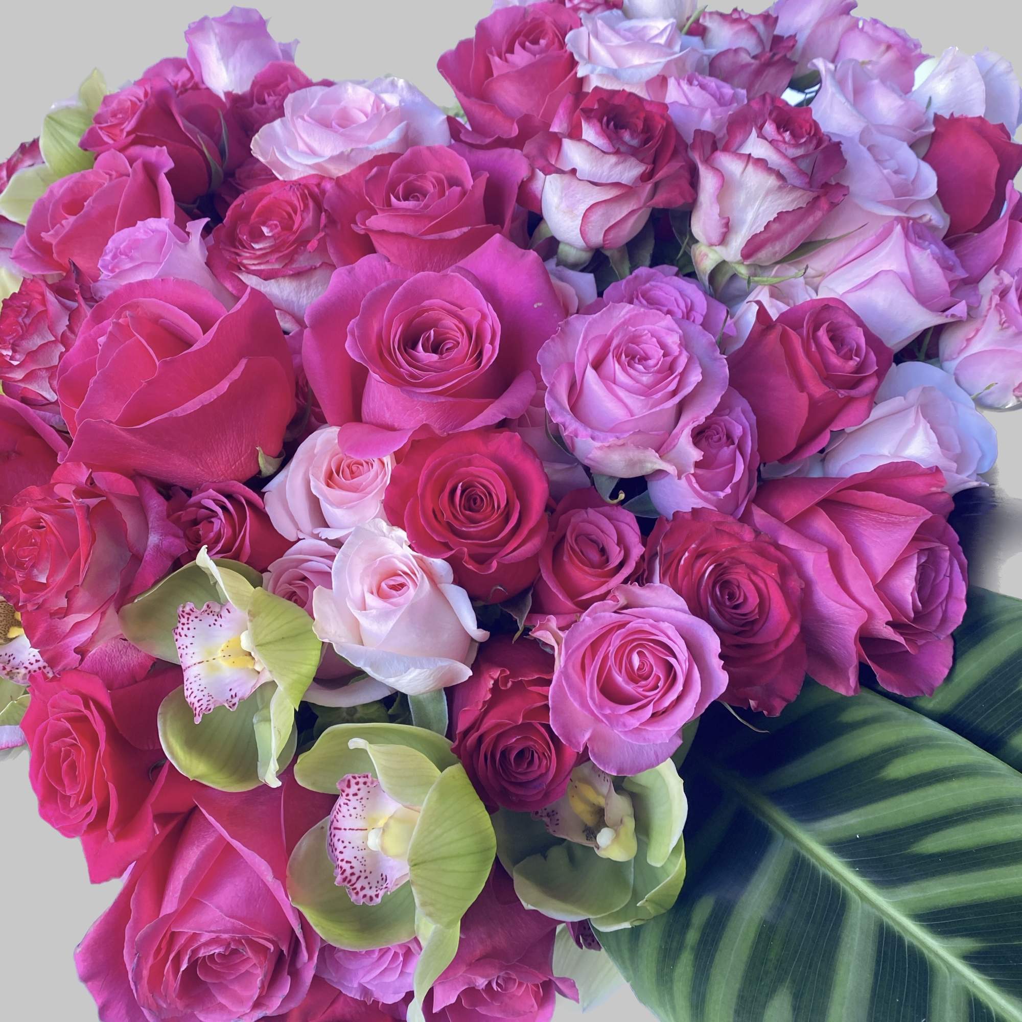 Bouquet of pink and lavender roses with green orchids