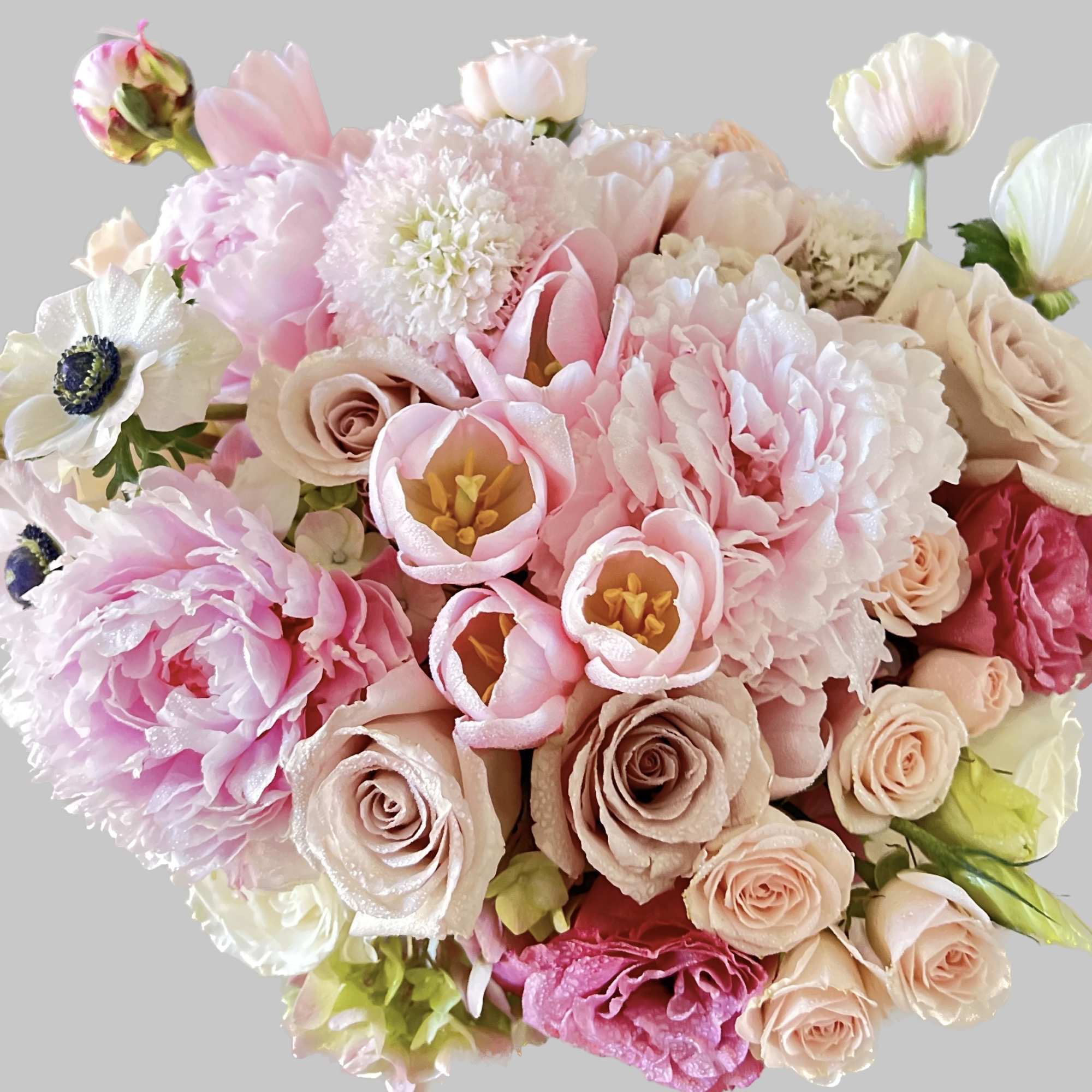 Bouquet of pink and cream flowers with roses and tulip-like blooms