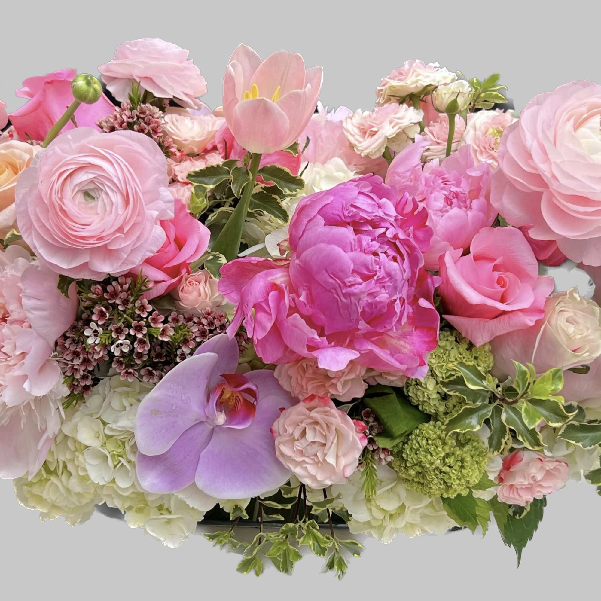 Pink floral arrangement with roses, peonies, orchids, and ranunculus