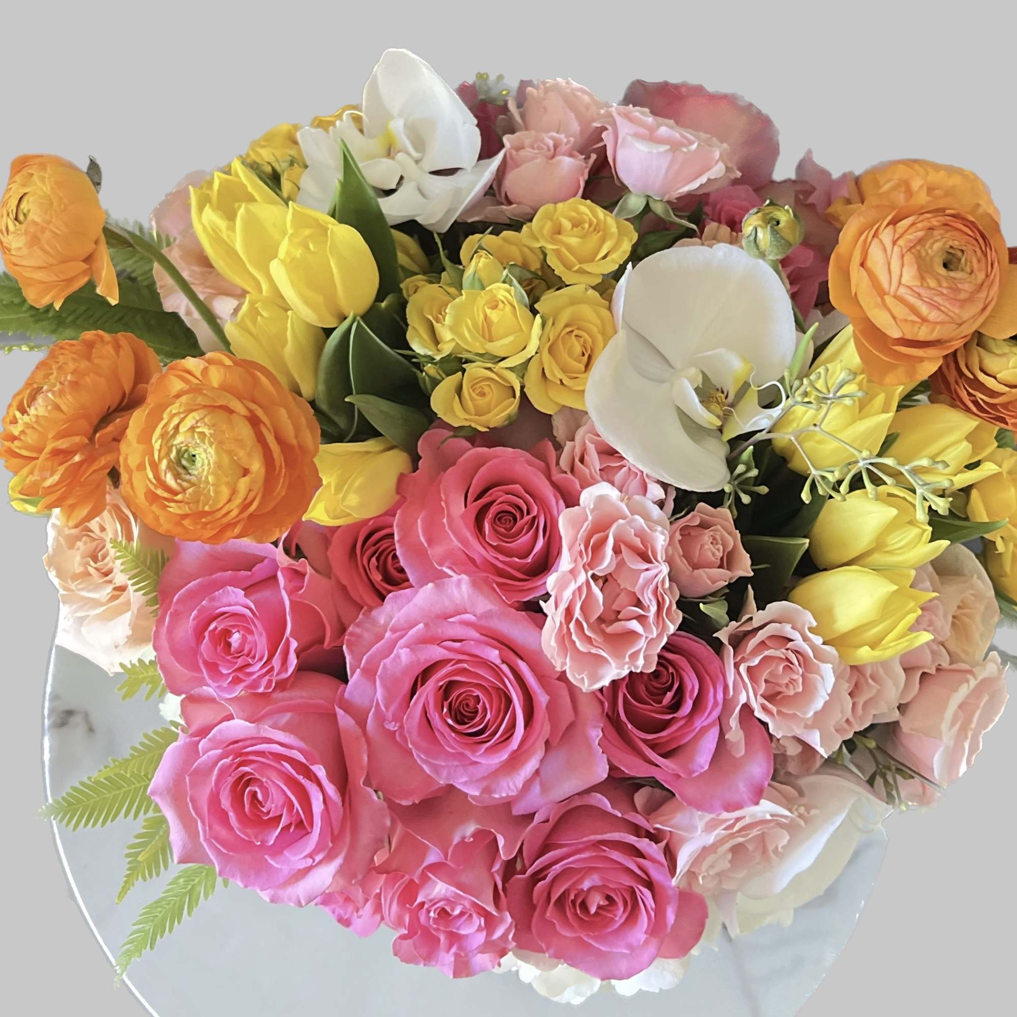 Bouquet of pink, yellow, orange, and white flowers on a round mirror
