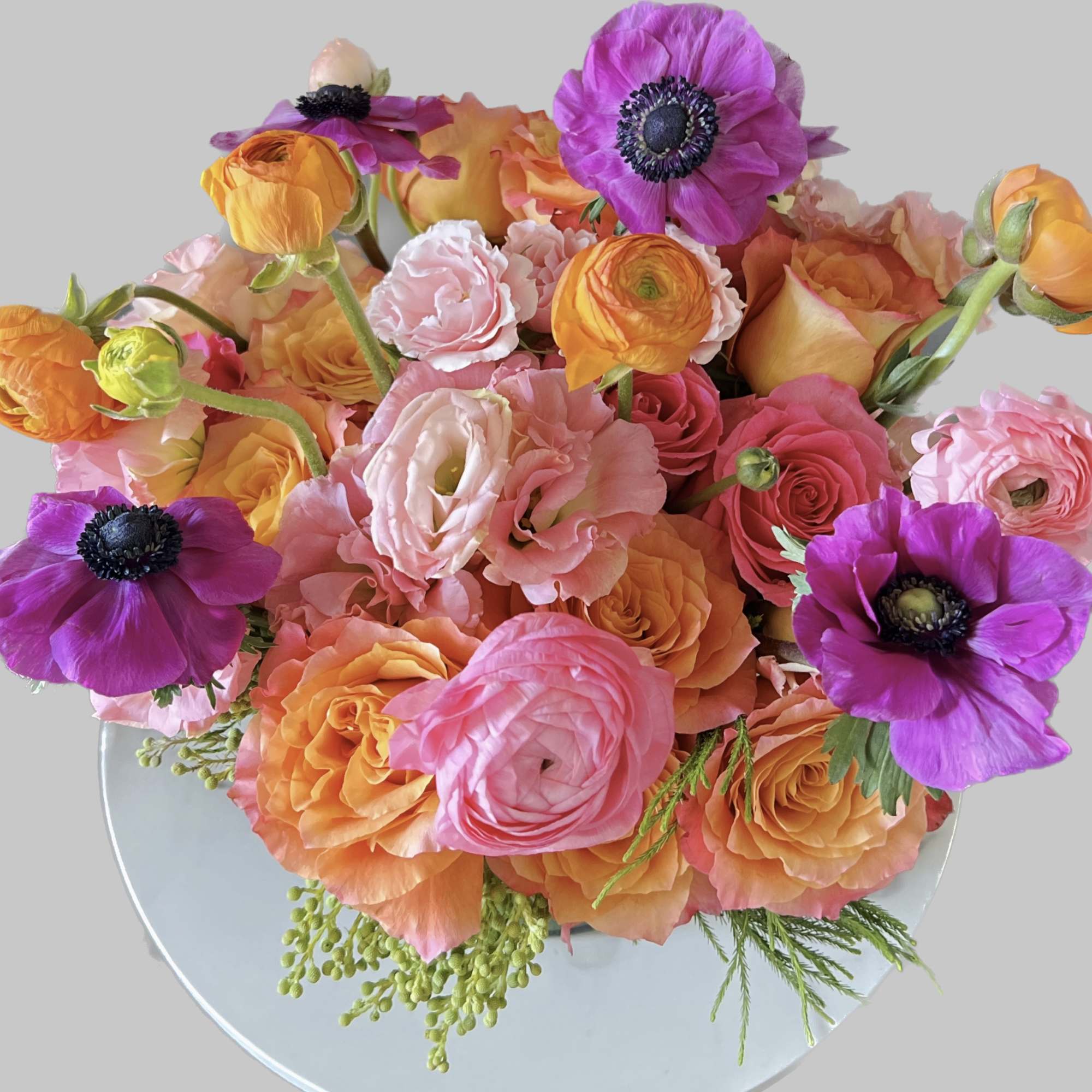 Bouquet of pink, orange, and purple flowers in a clear vase