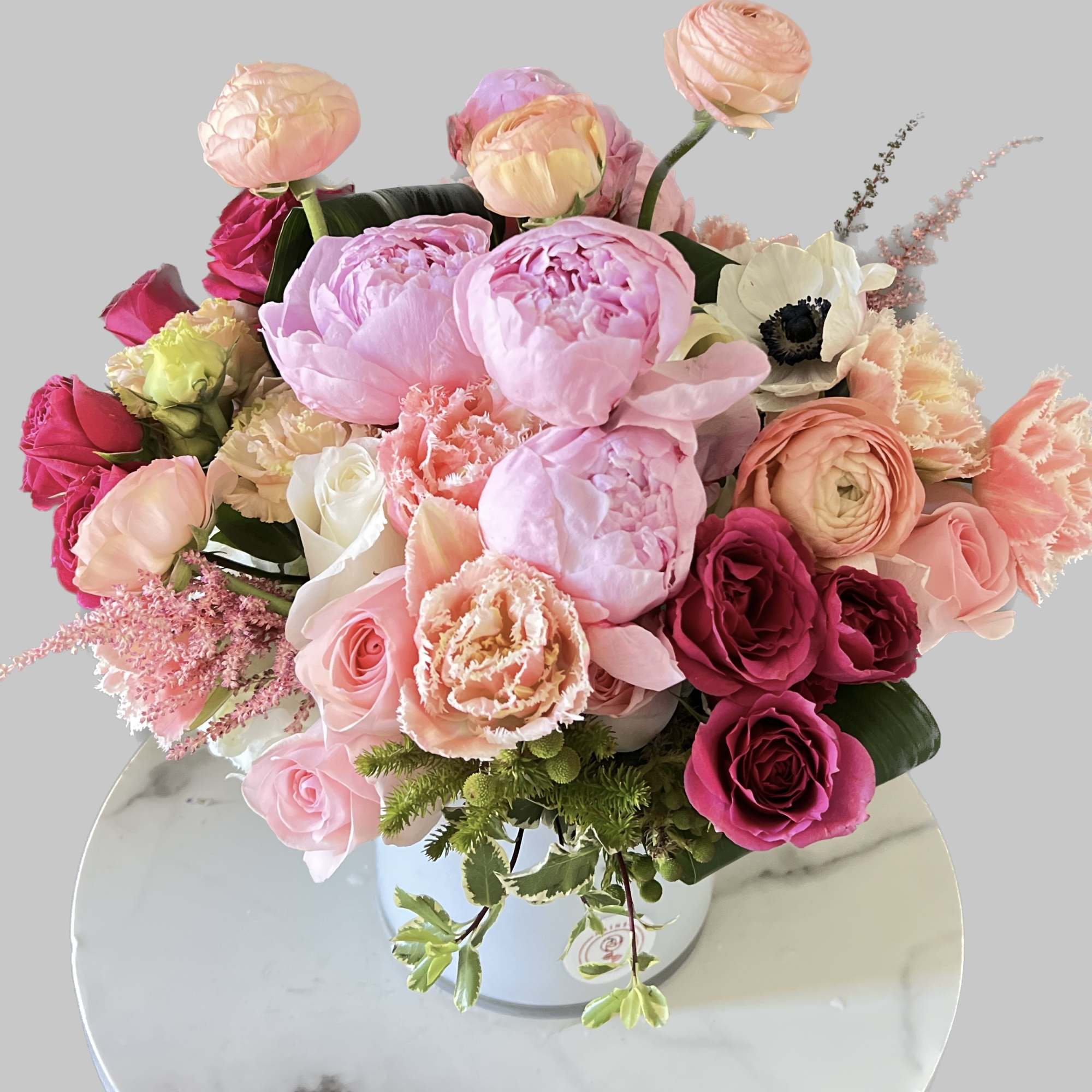 Pink and peach mixed bouquet in a white vase
