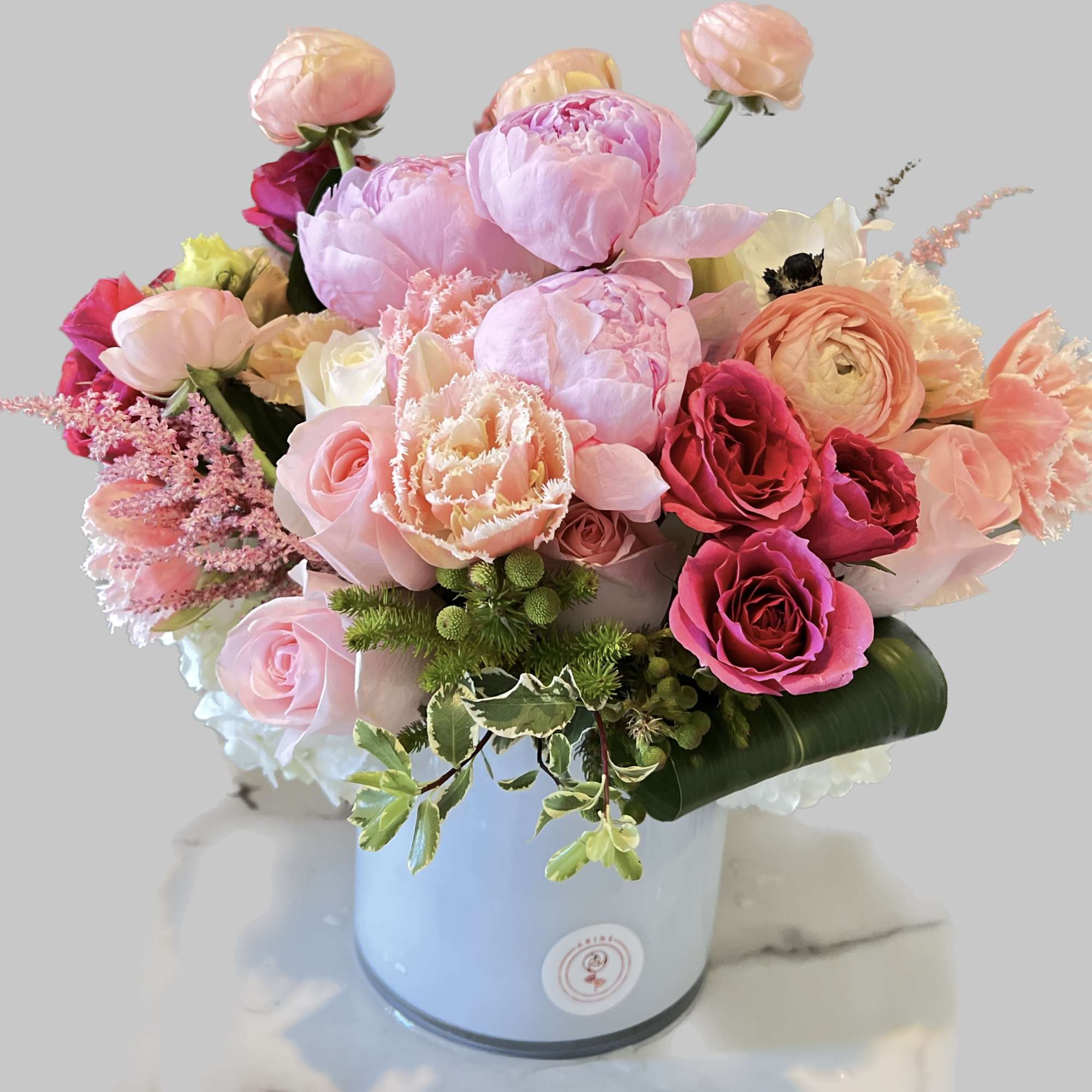 Pink and peach mixed flower arrangement in a light blue vase