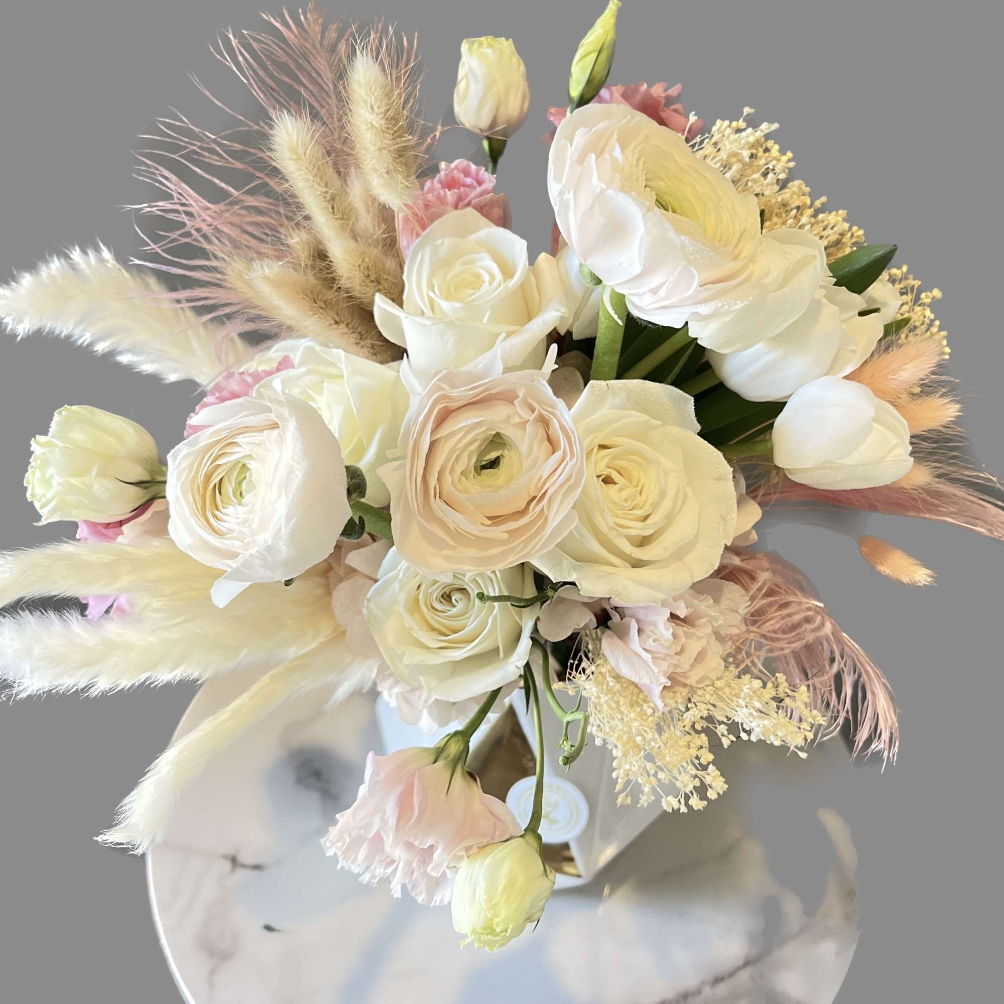 Cream and blush bouquet with roses and ranunculus in a vase
