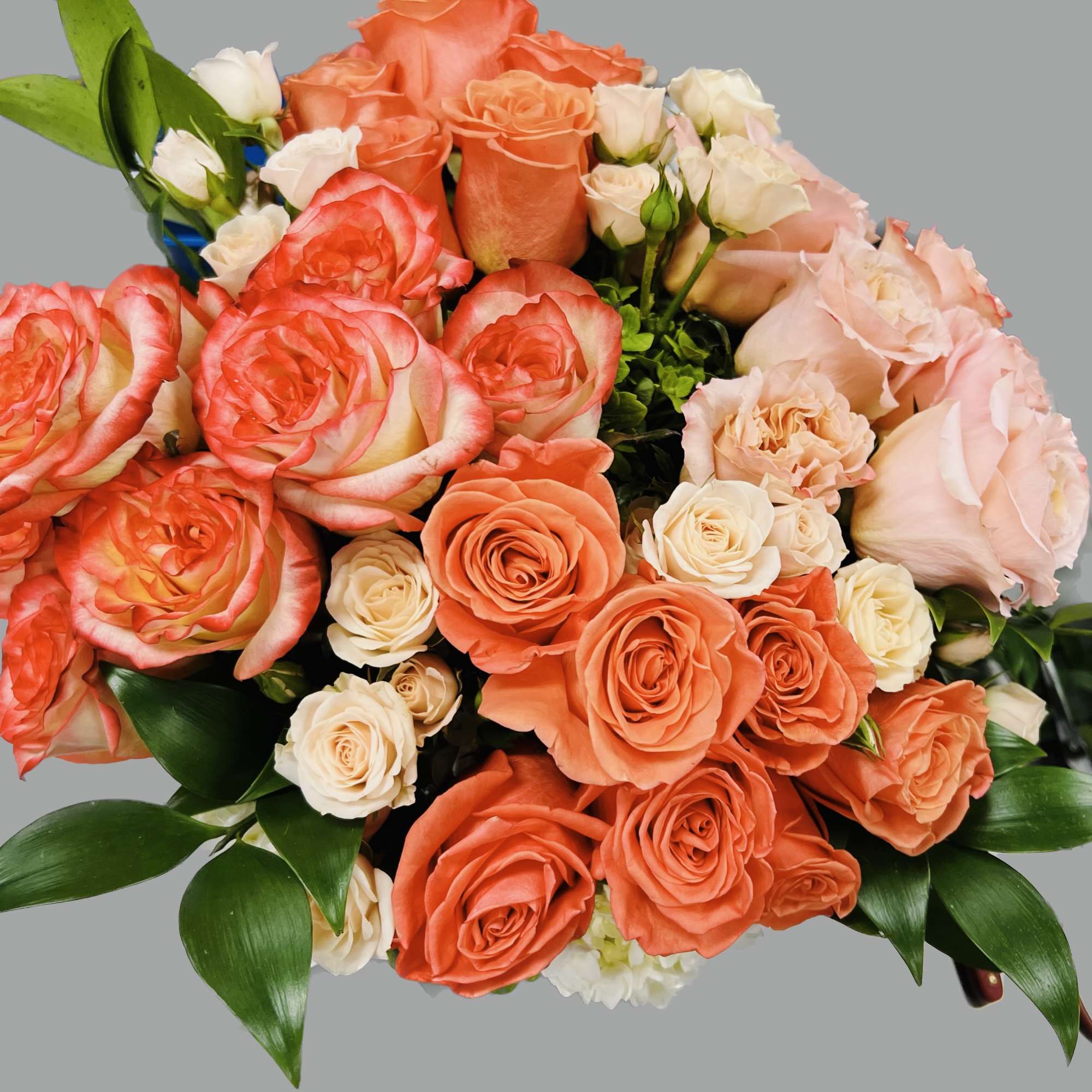 Bouquet of coral and blush roses with white spray roses