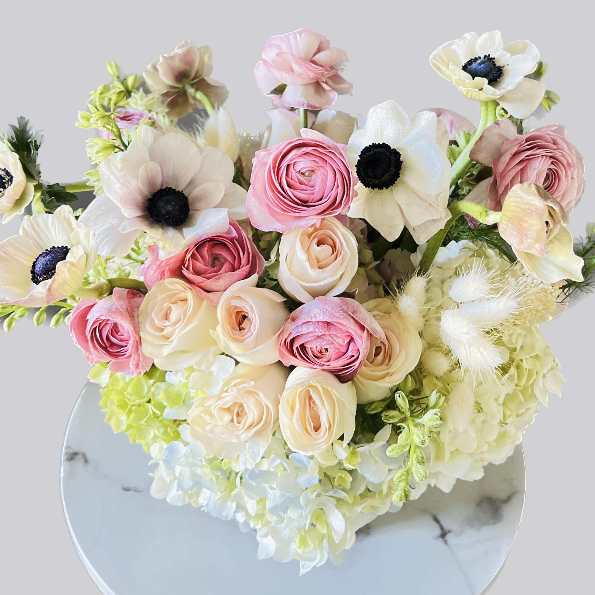 Bouquet of pink and cream flowers with white blooms in a round vase