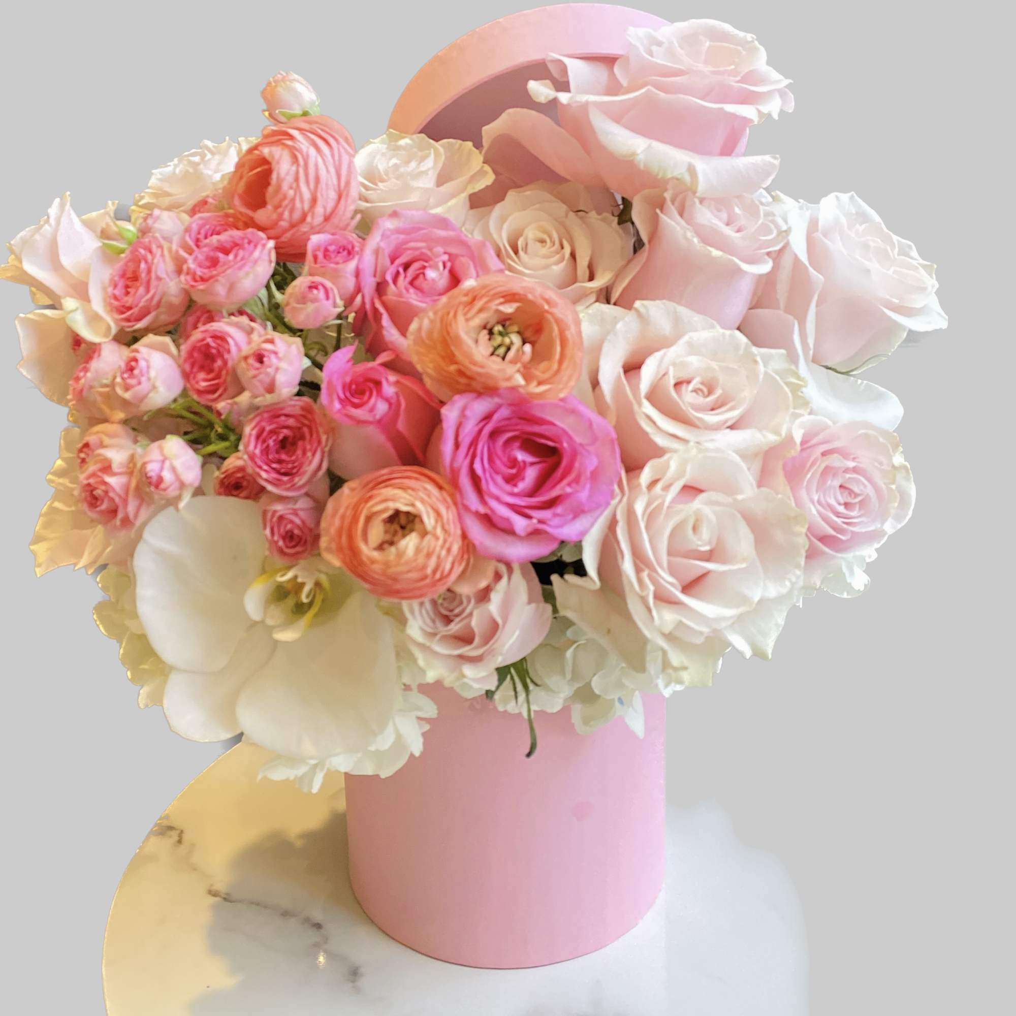 Pink and white rose bouquet in a pink cylindrical box