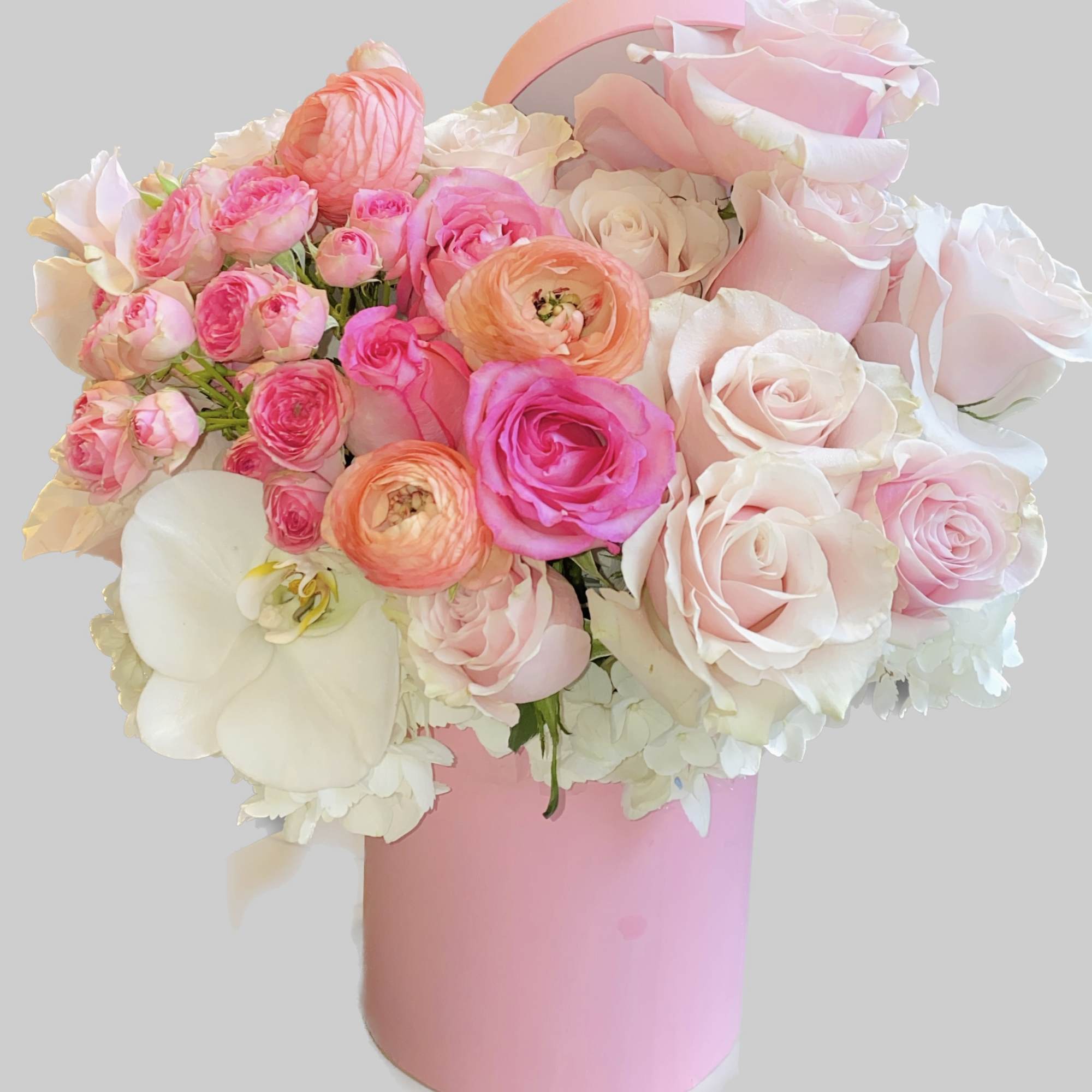 Pink and white roses with orchids in a pink cylindrical box