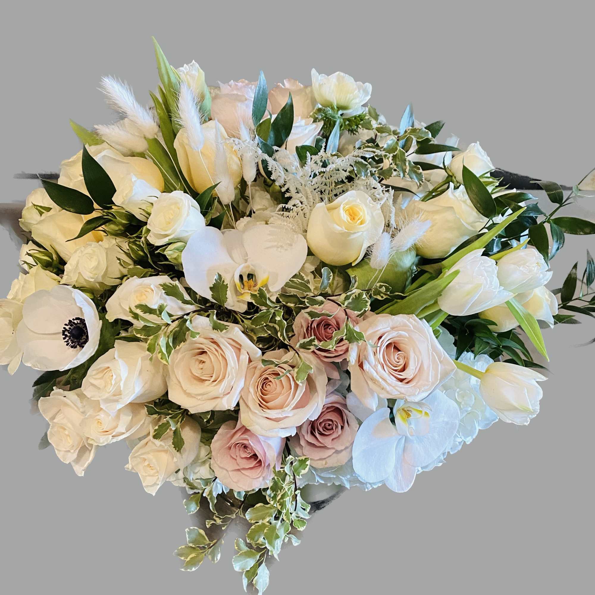 Bouquet of white and blush roses with white orchids and greenery