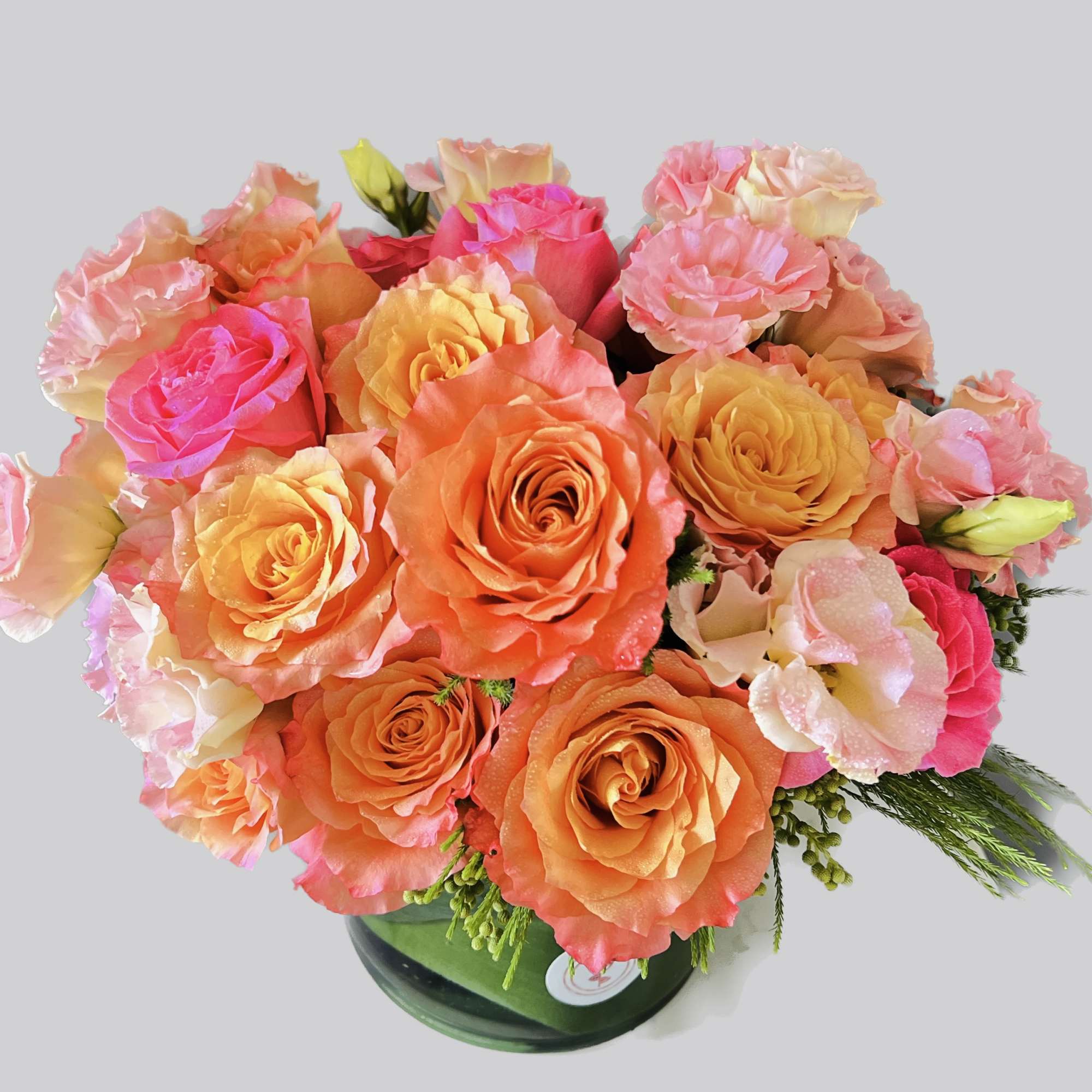 Bouquet of orange and pink roses in a glass vase