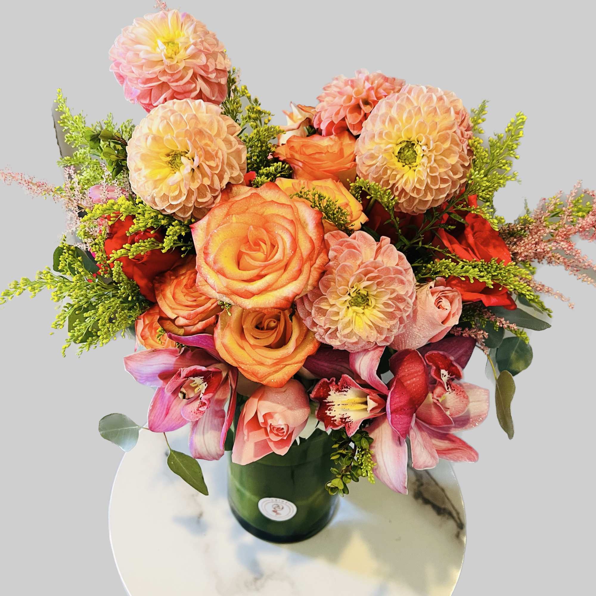 Bouquet of peach and pink flowers in a green vase
