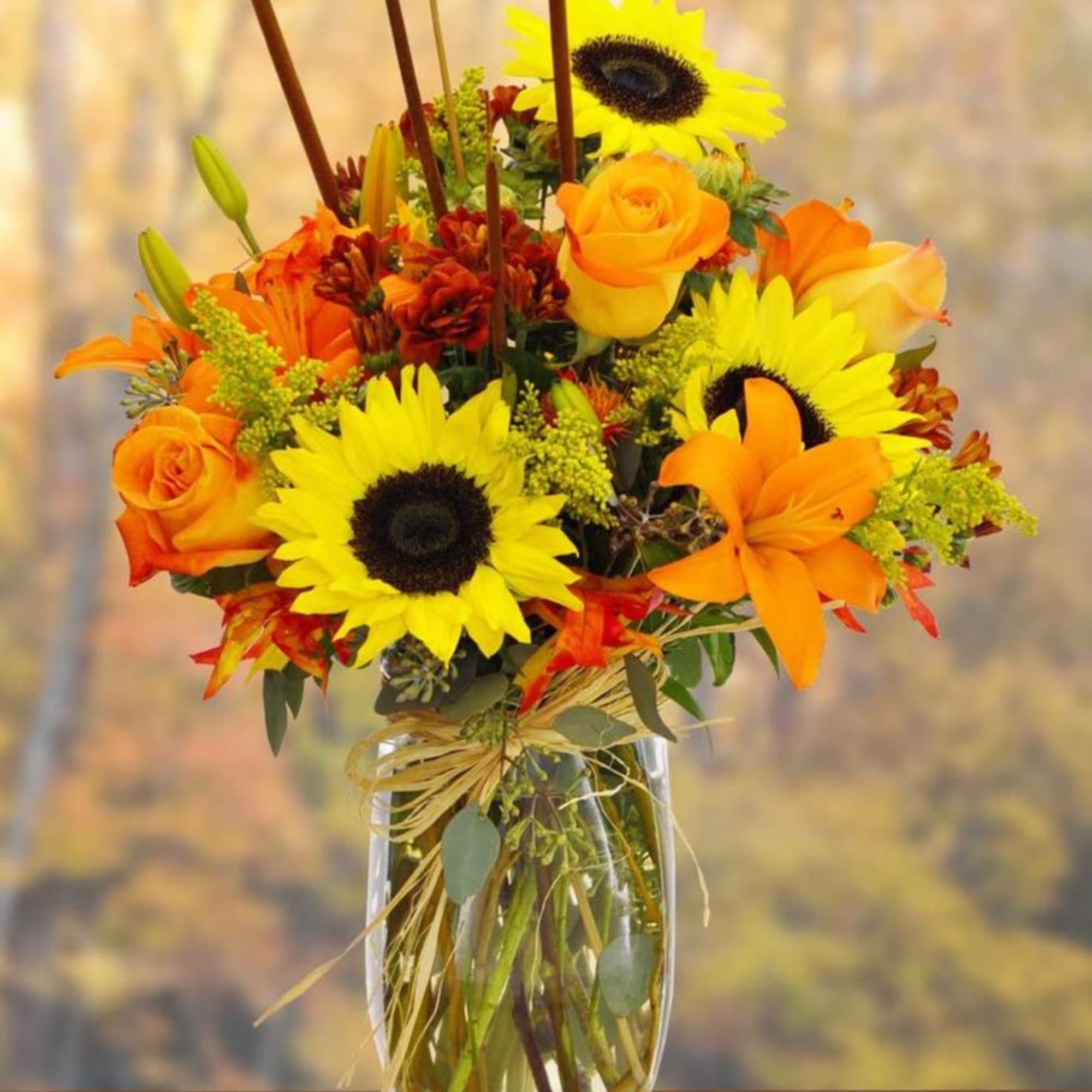 Orange and yellow flower arrangement in a clear glass vase