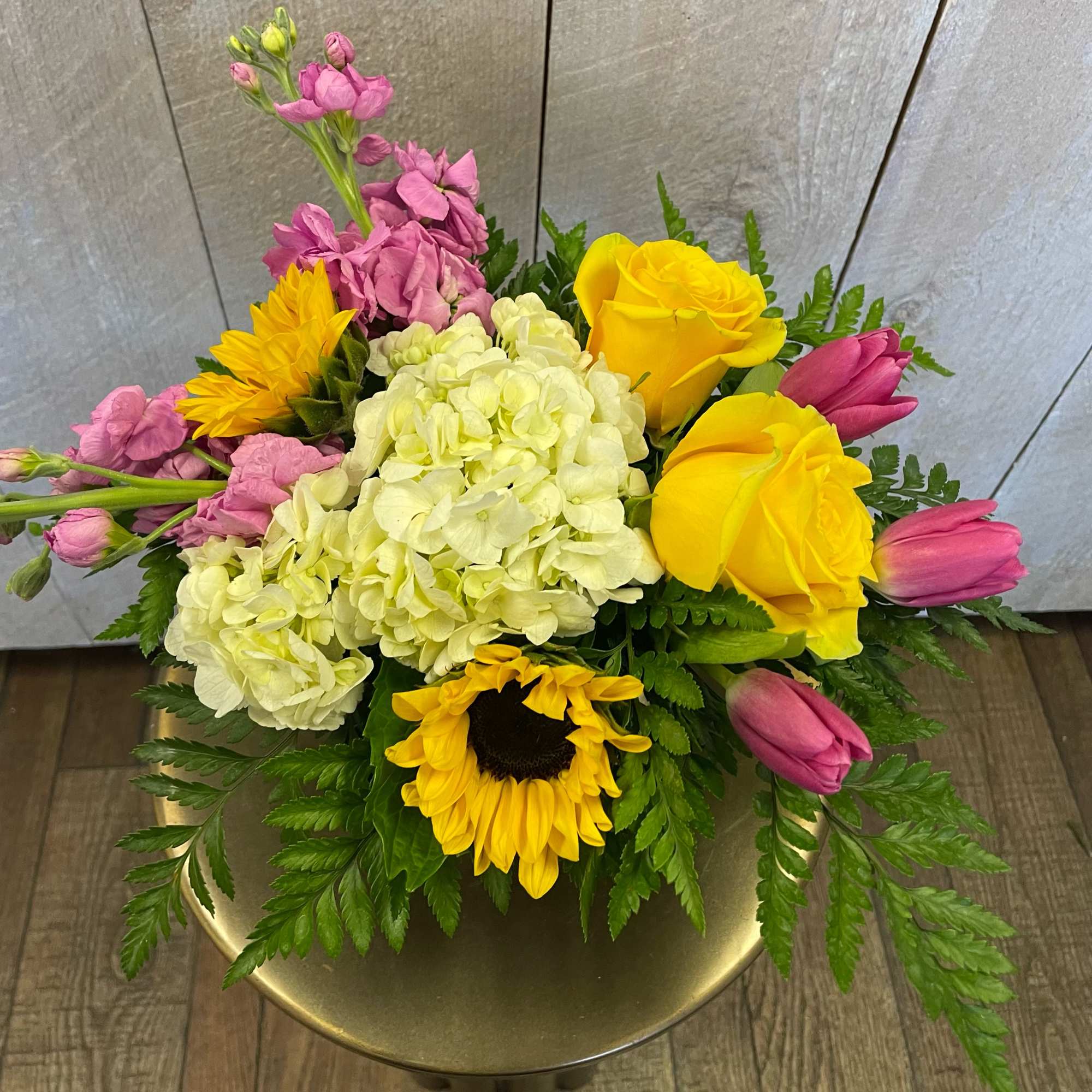 Bouquet of yellow roses, pink tulips, hydrangea, and sunflowers