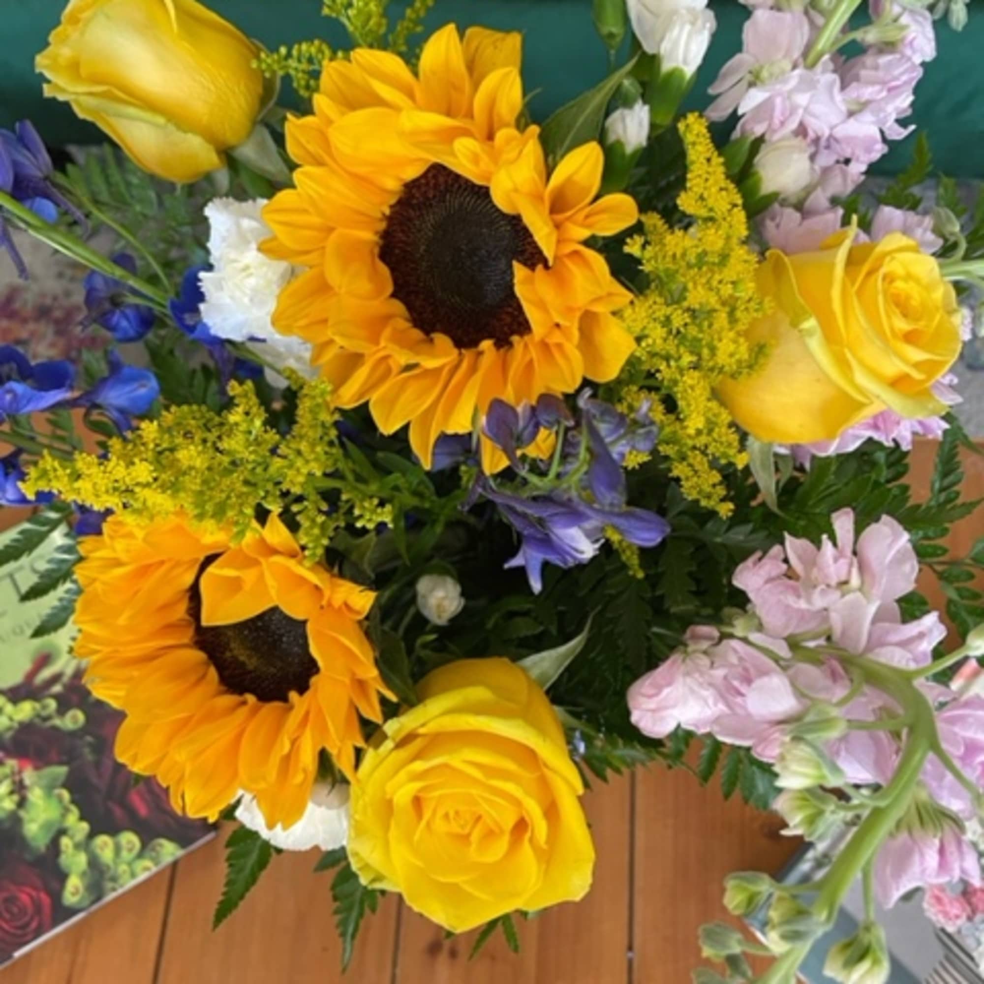 Bouquet of yellow roses, sunflowers, and purple flowers