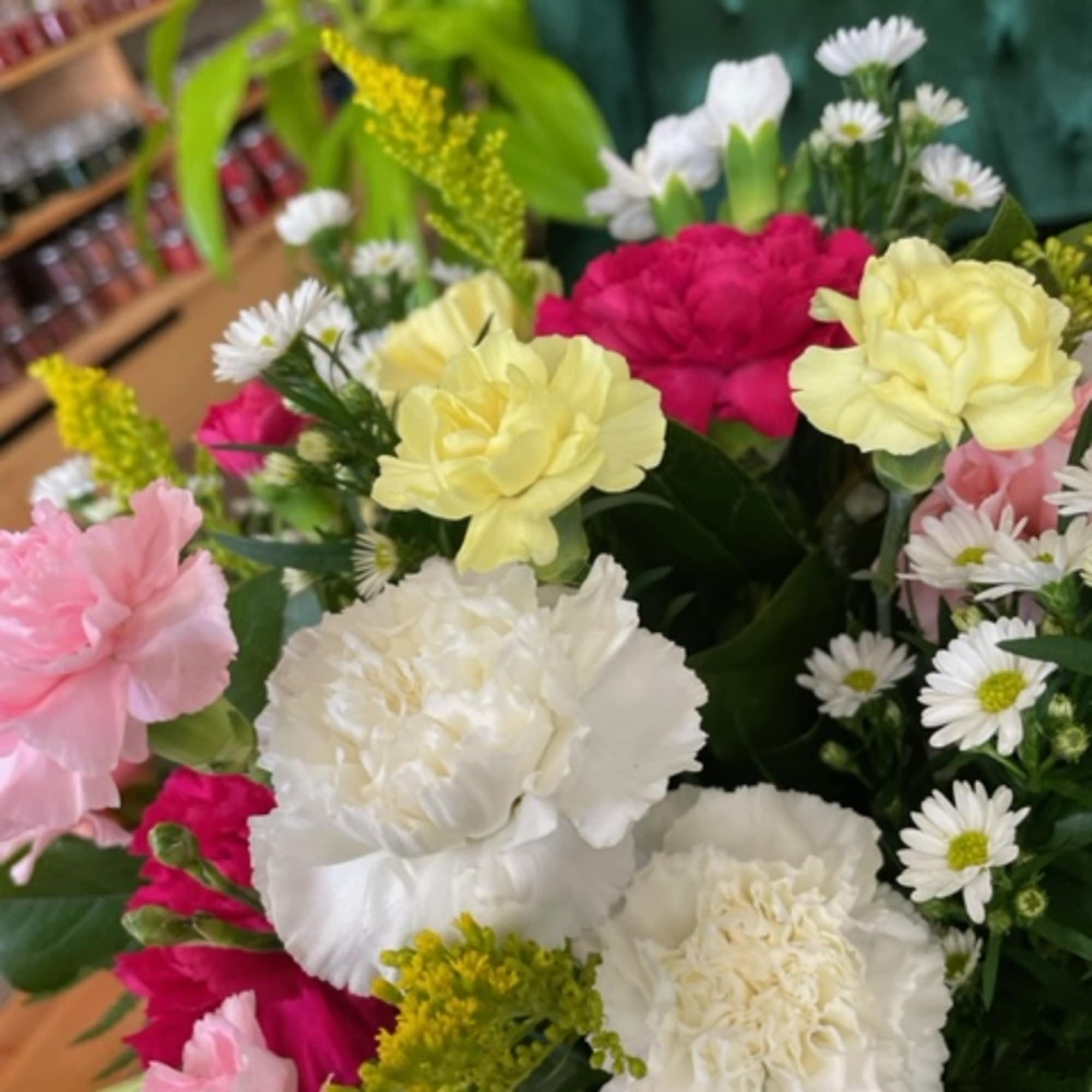 Mixed bouquet of carnations and small white daisies in pink, yellow, and white