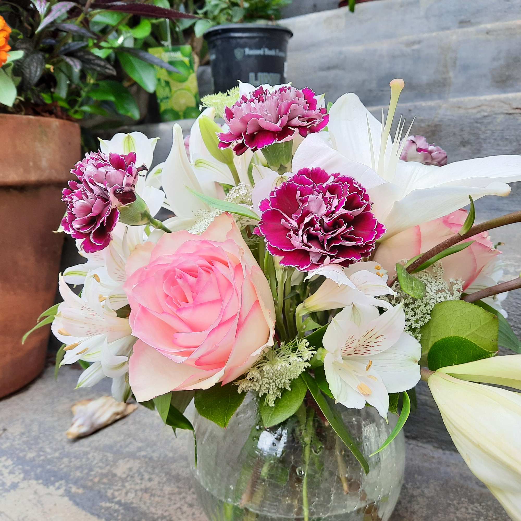 Pink rose and white lily bouquet in a glass vase
