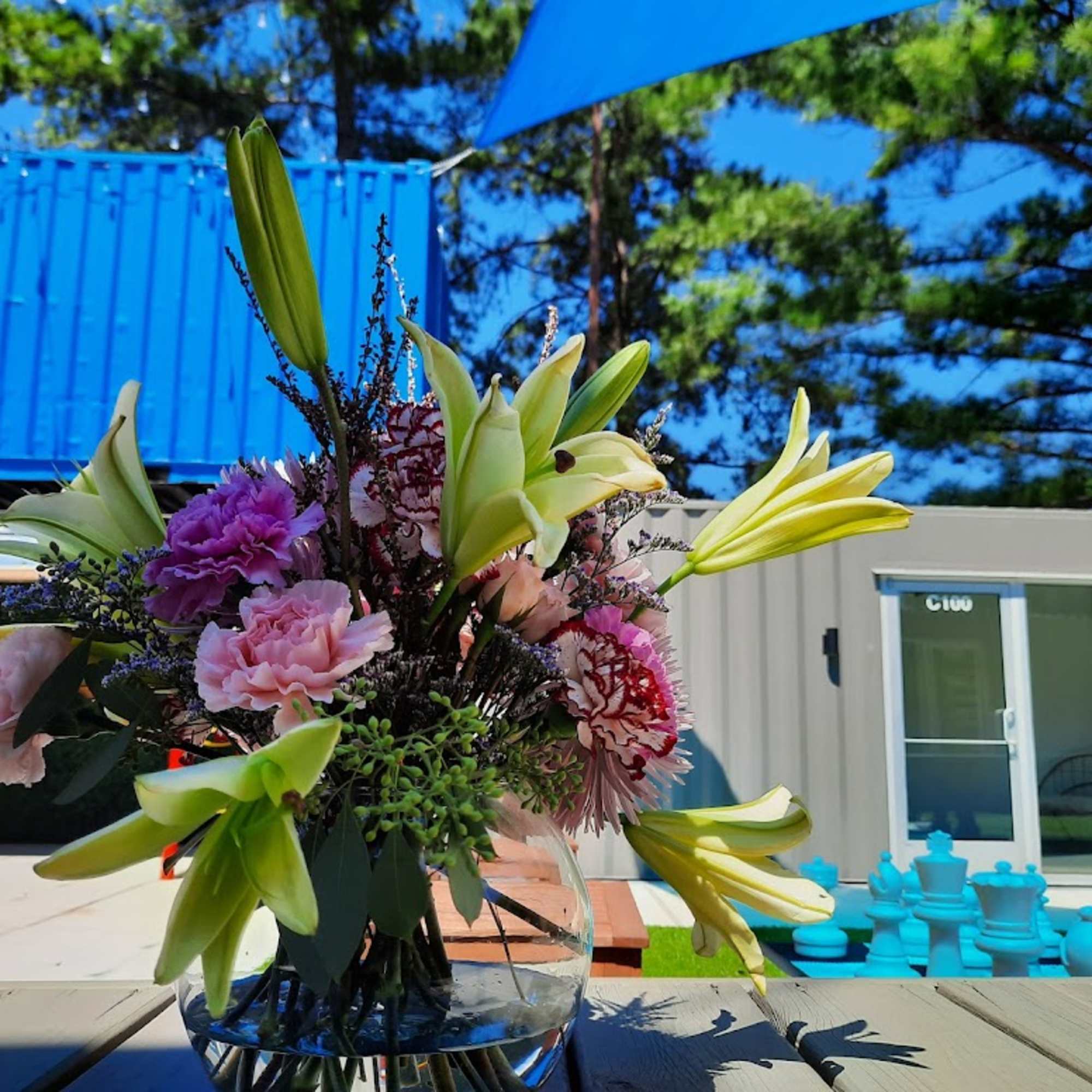 Mixed bouquet with lilies, carnations, and other blooms in a glass vase