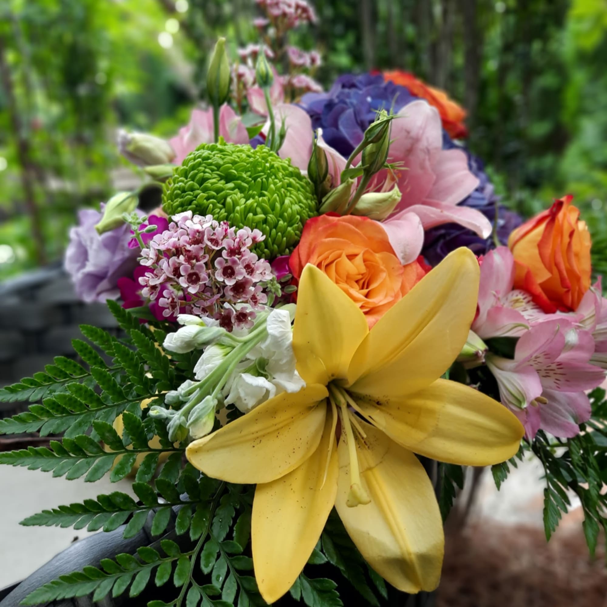 Colorful bouquet with yellow lily, orange roses, and pink blooms