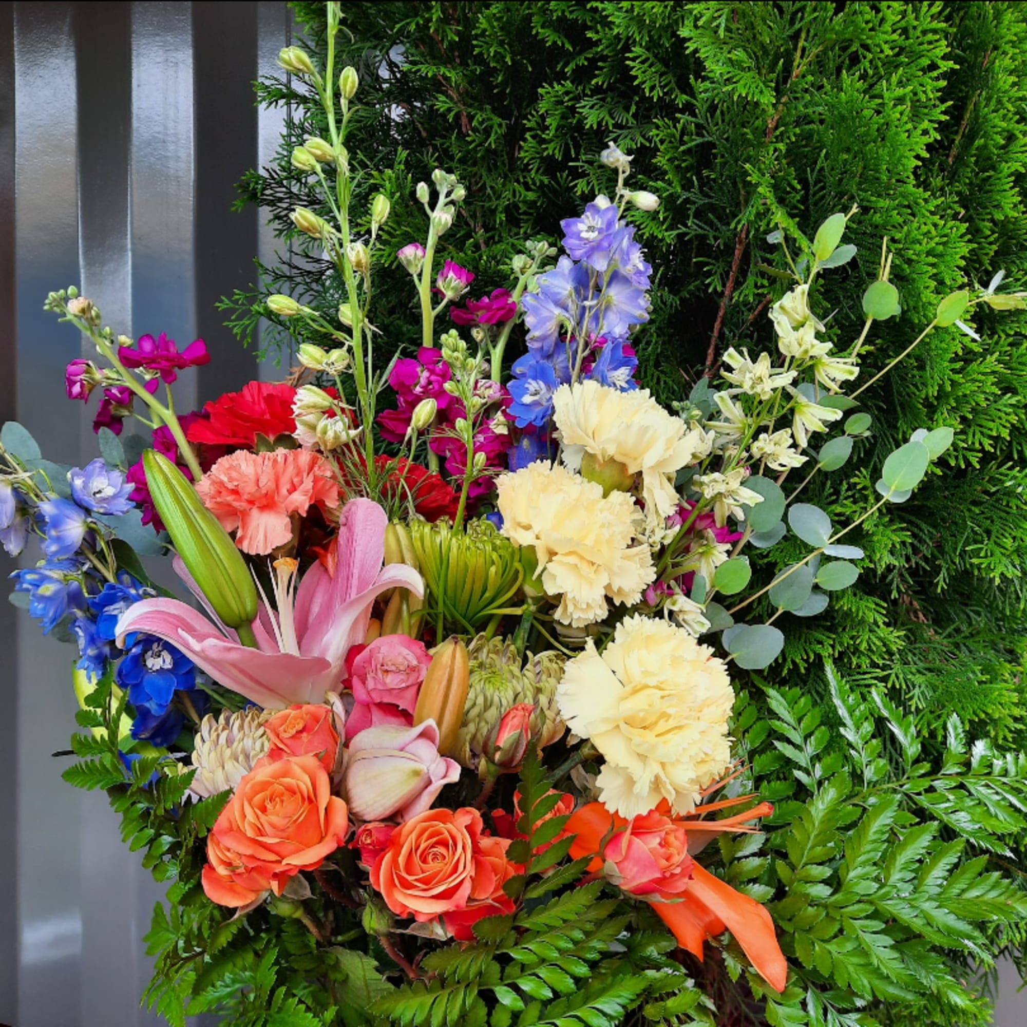 Colorful mixed bouquet with lilies, roses, carnations, and blue flowers