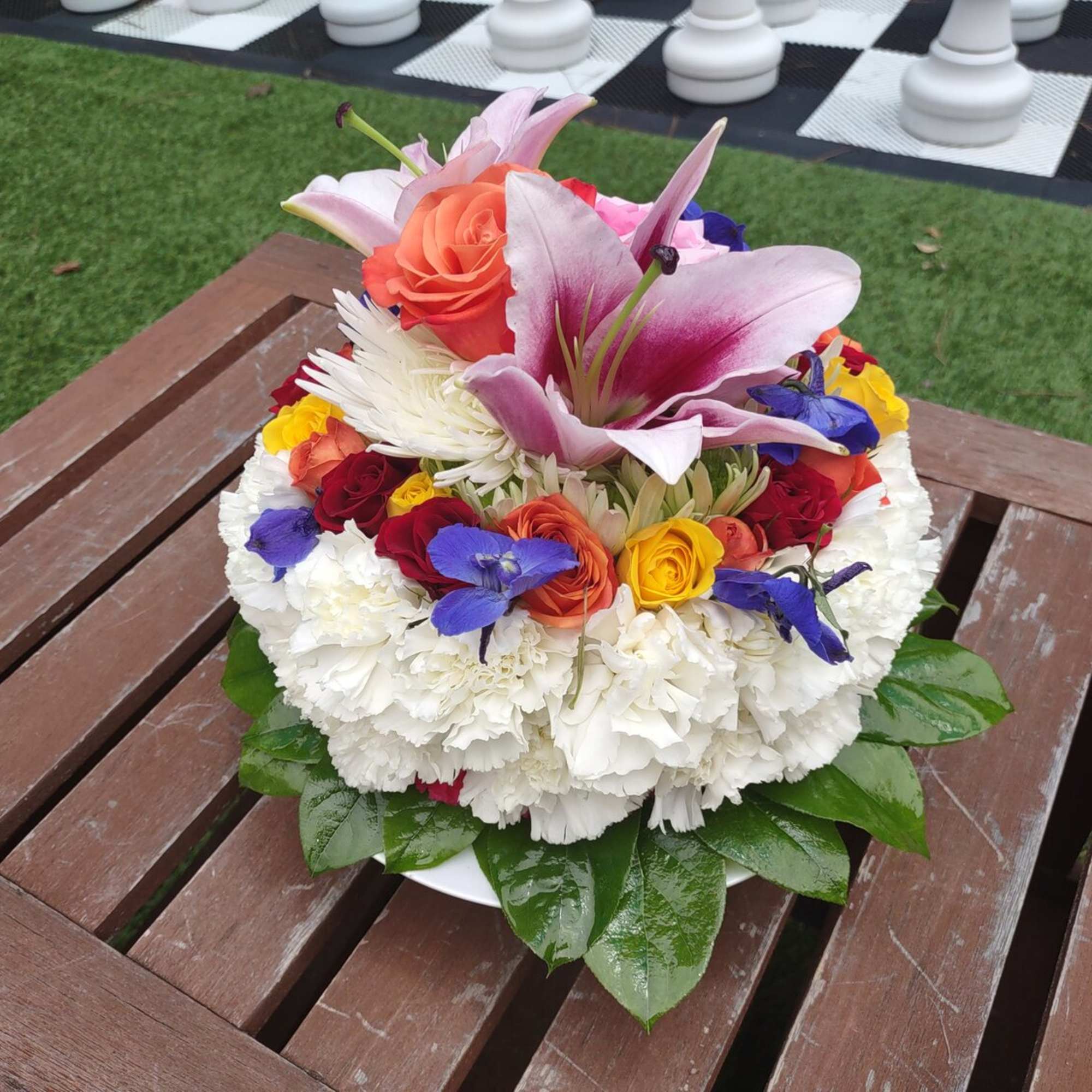 Colorful mixed flower arrangement in a low white dish