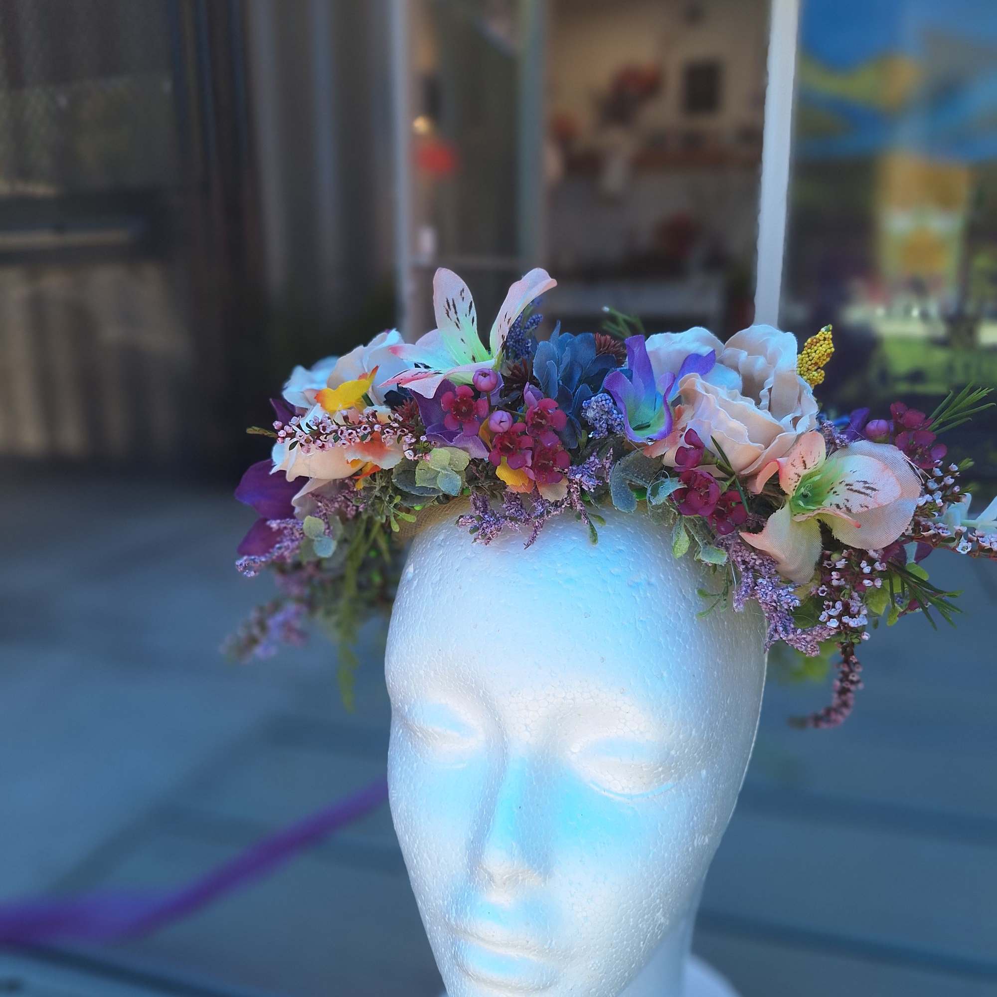 Floral crown with pastel flowers on a white mannequin head