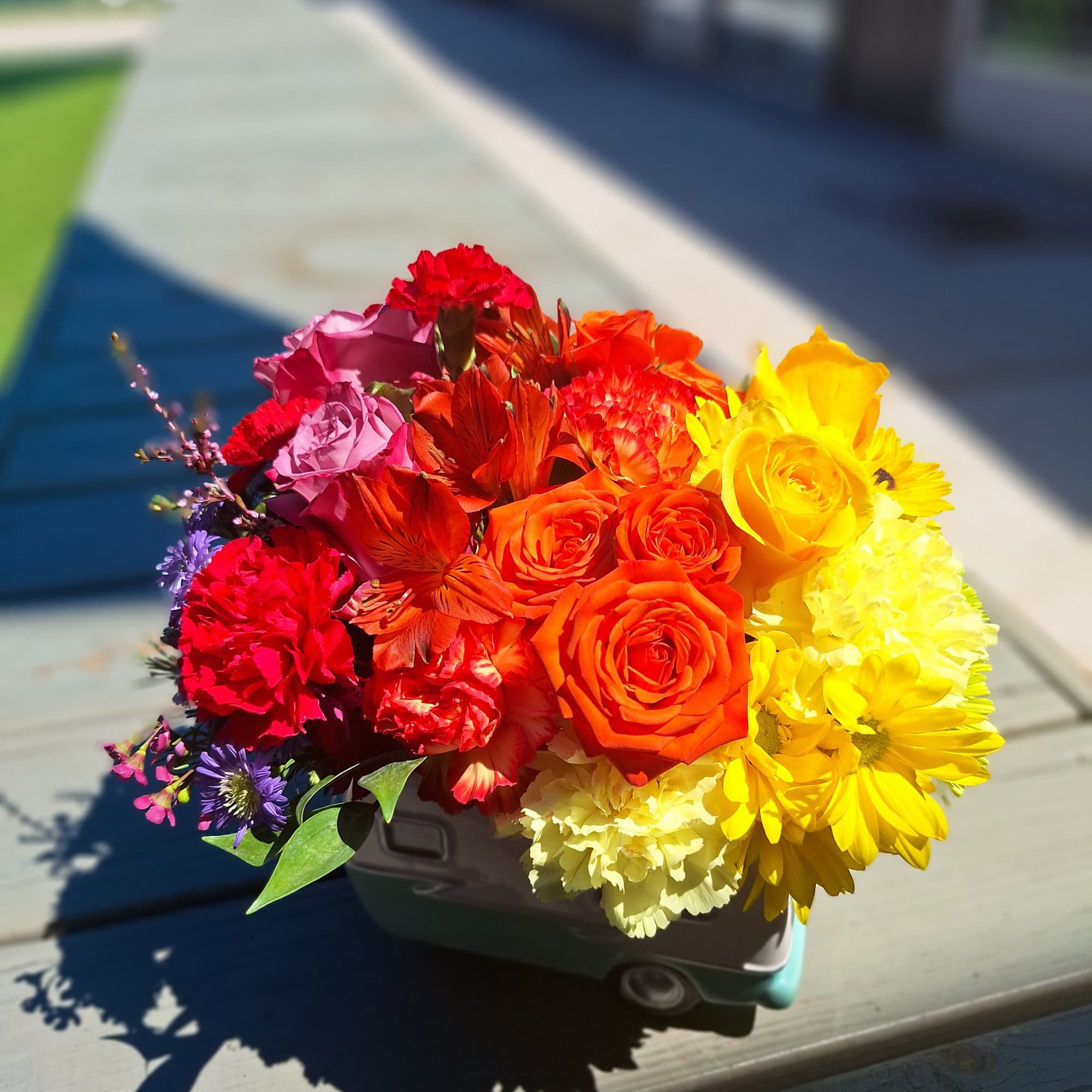 Bright mixed bouquet in a small toy car container