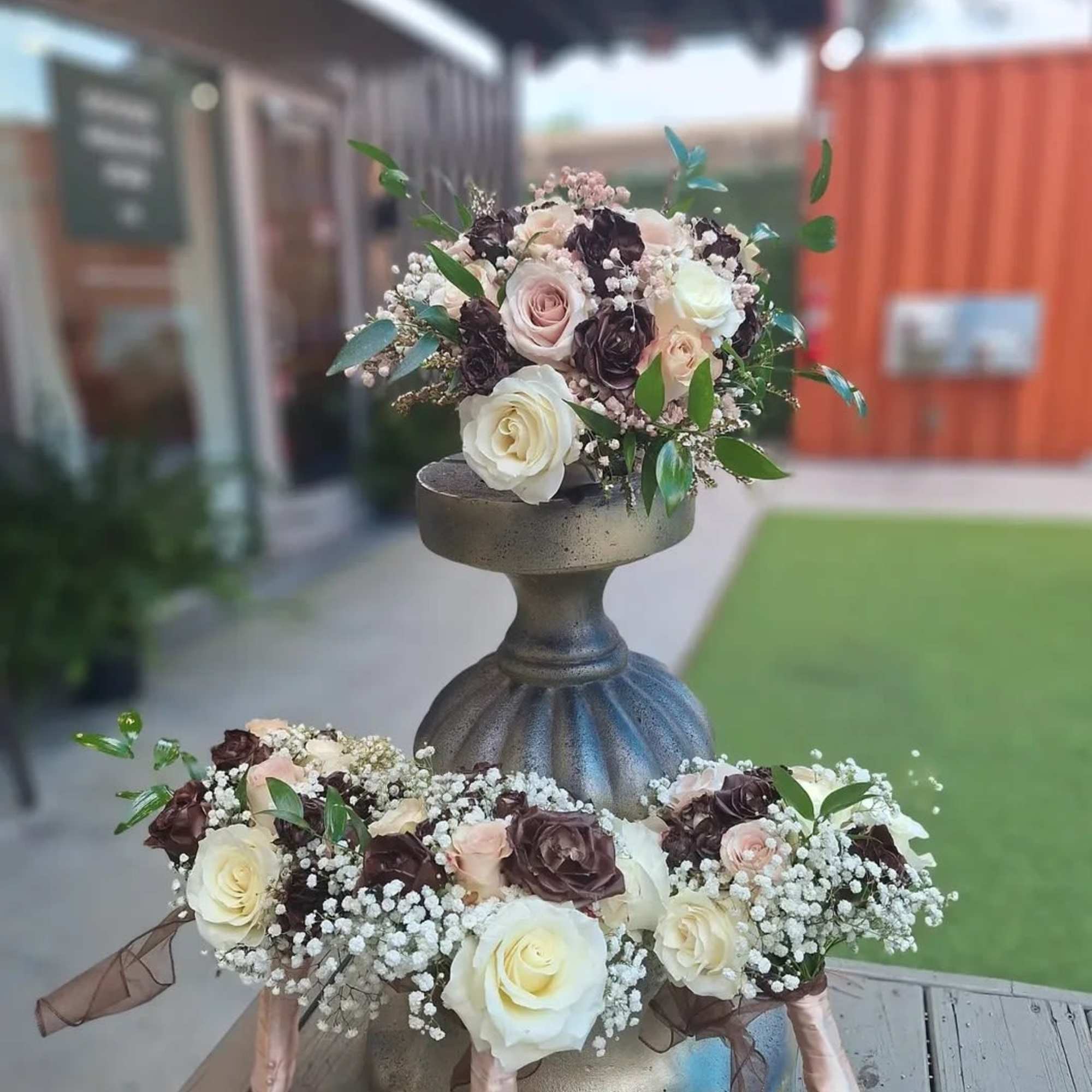 Two rose bouquets arranged on a pedestal stand
