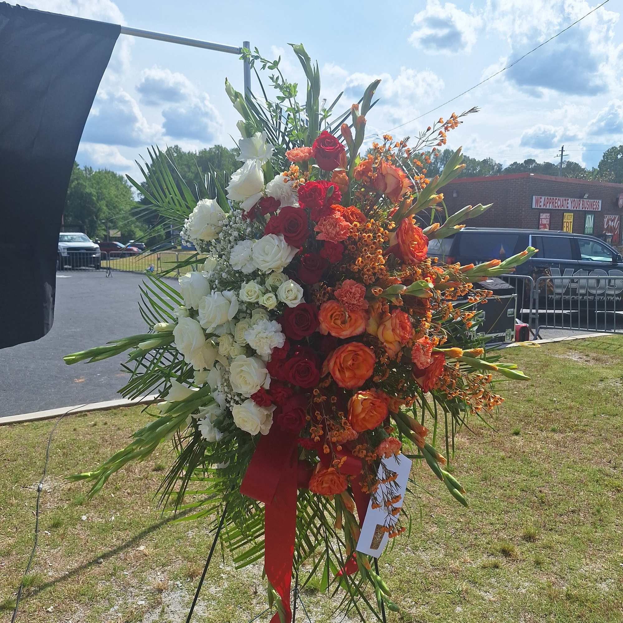Large standing floral spray with red, white, and orange flowers
