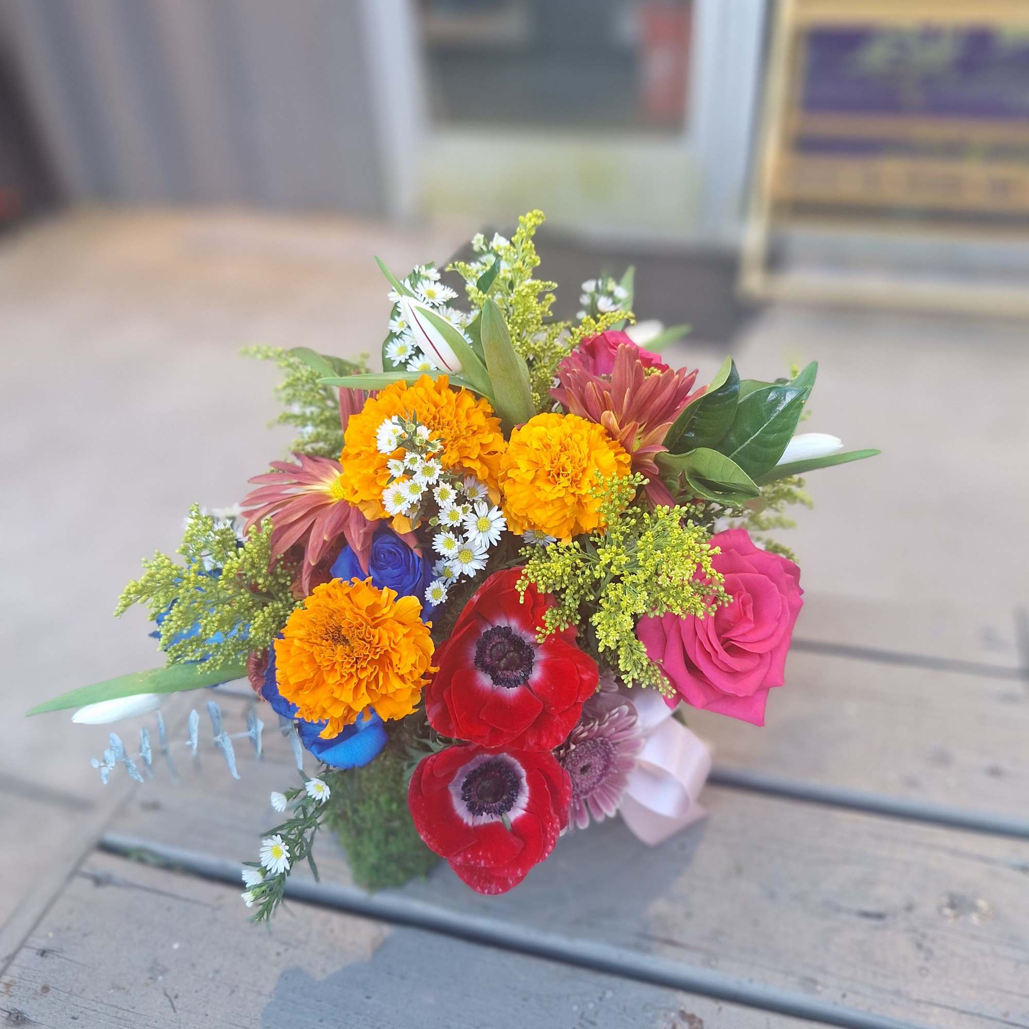 Colorful mixed bouquet with roses, marigolds, and anemones