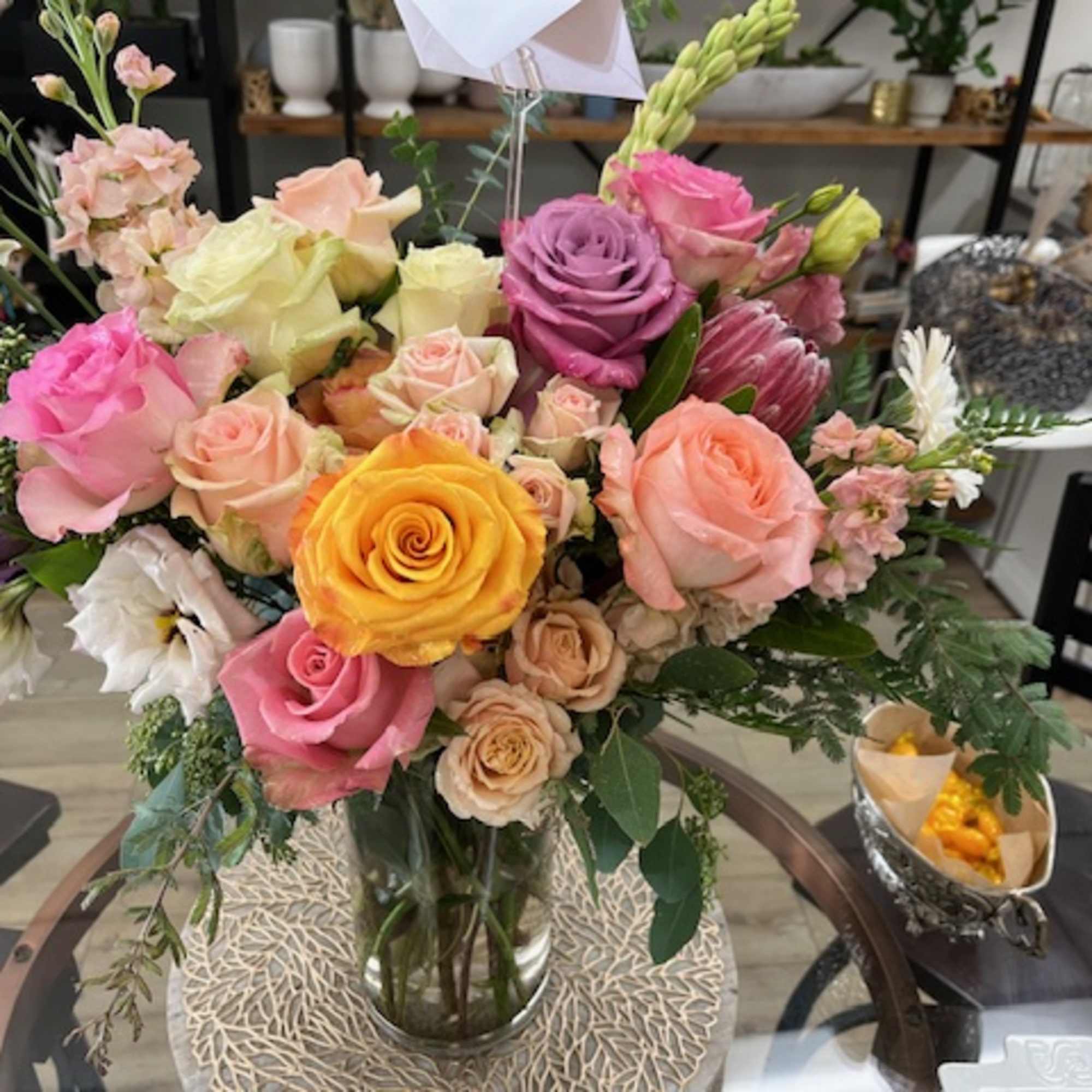 Mixed bouquet of roses and other blooms in a glass vase, photo 3 of 3
