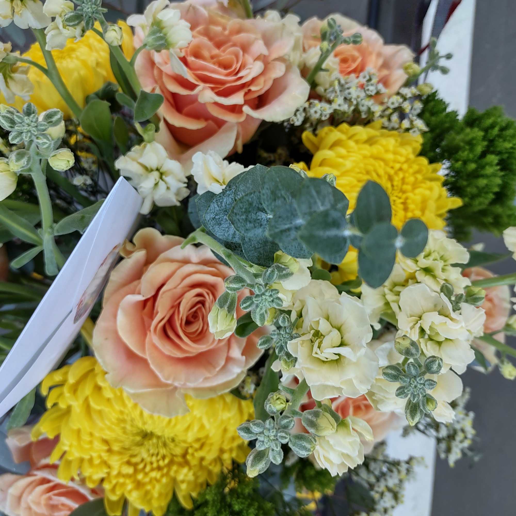 Bouquet of peach roses, yellow chrysanthemums, and white flowers